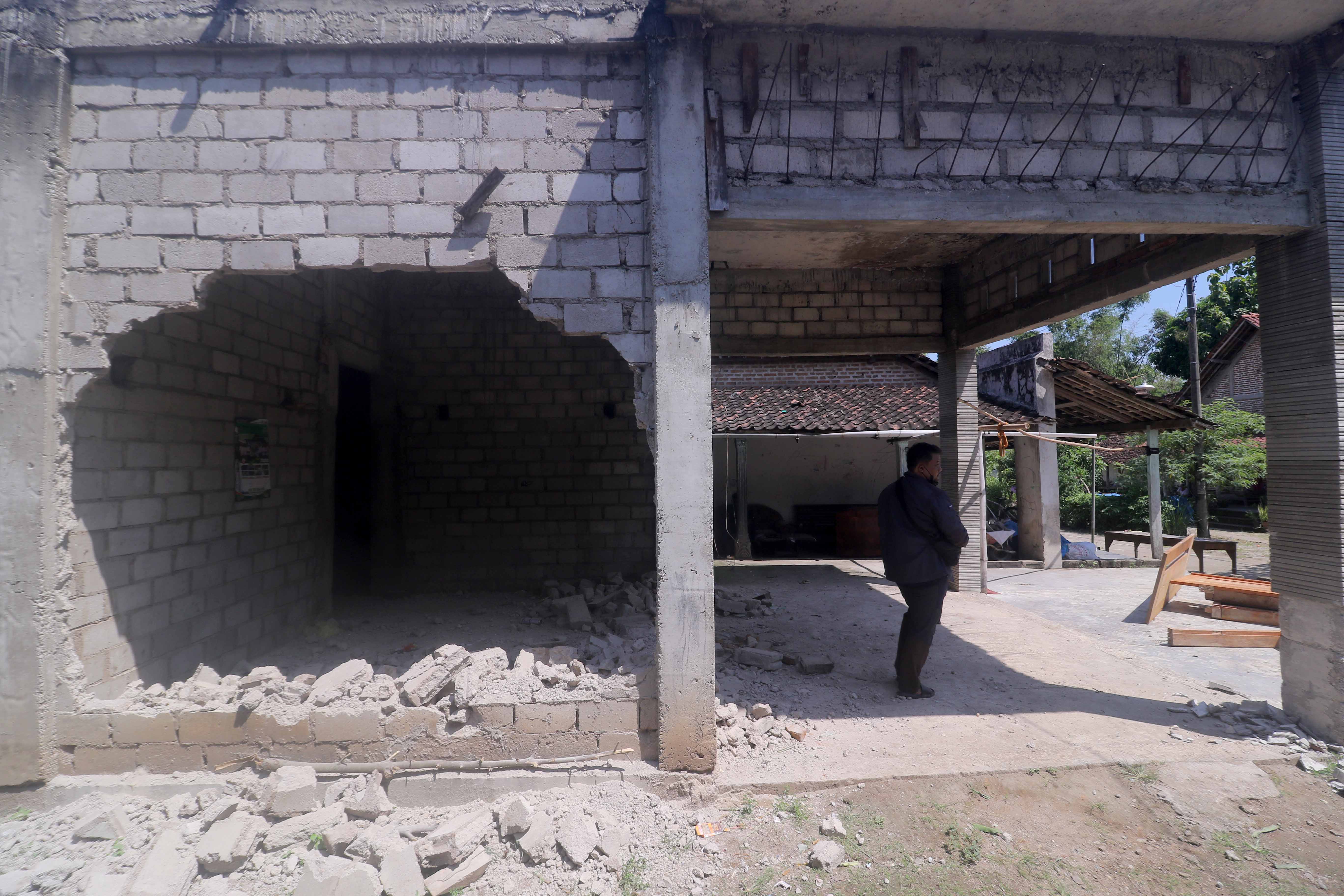 HAMPIR ROBOH: Kondisi rumah Siti Fatimah yang hendak dirobohkan dengan eskavator di Desa Pucanganom, Kebonsari, Jumat (19/4). (R. BAGUS RAHADI/RADAR MADIUN)