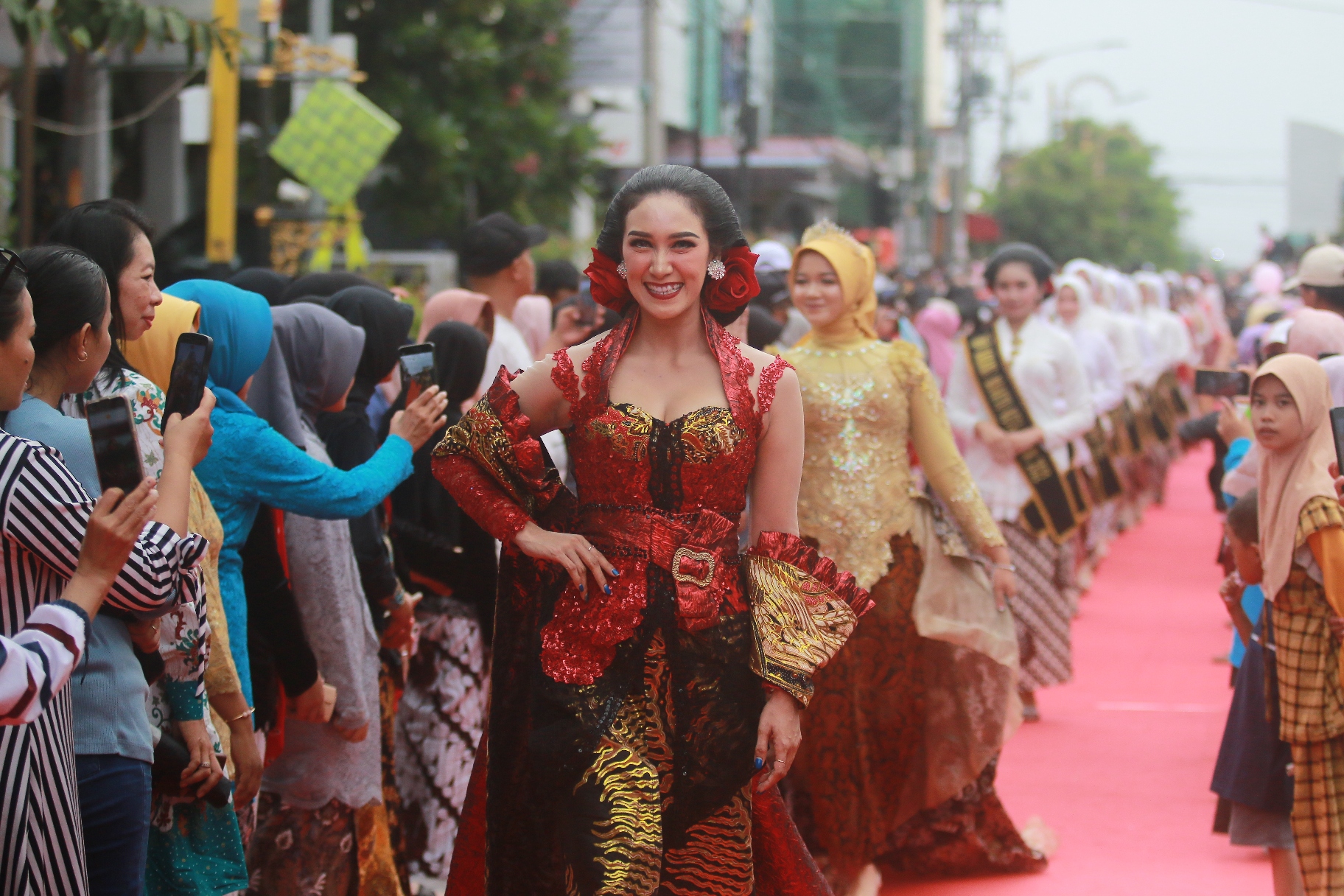 PECAH REKOR: Para model perempuan dengan mengenakan kebaya berlenggak-lenggok di atas catwalk sepanjang 1.009 meter yang membentang di Jalan Pahlawan, Sabtu (20/4) lalu. (BAGAS BIMANTARA/RADAR MADIUN)