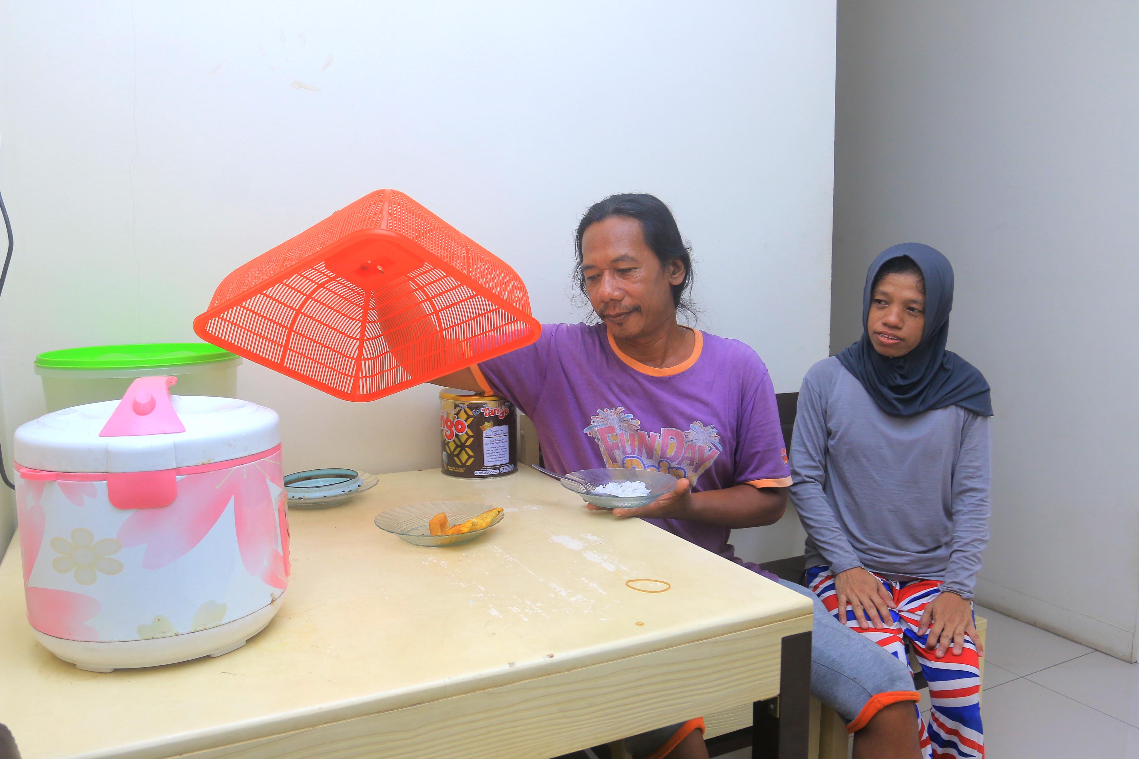 HANGAT: Tutik bersama suami di meja makan salah satu hunian di rusunawa II Kota Madiun. (BAGAS BIMANTARA/RADAR MADIUN)