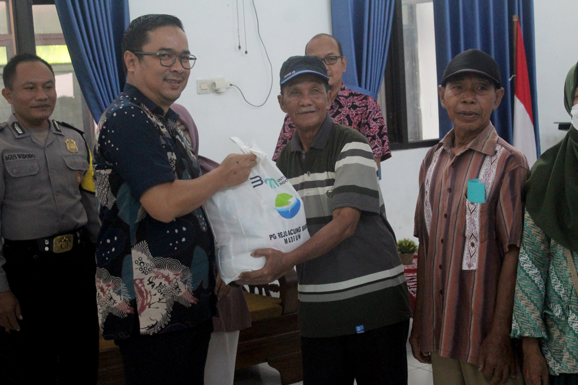PEDULI: General Manager PG Rajawali I Unit PG Rejo Agung Baru Madiun Immam Nur Salamet saat menyerahkan paket sembako kepada warga Kelurahan Tawangrejo kemarin (30/4). (ISTIMEWA)