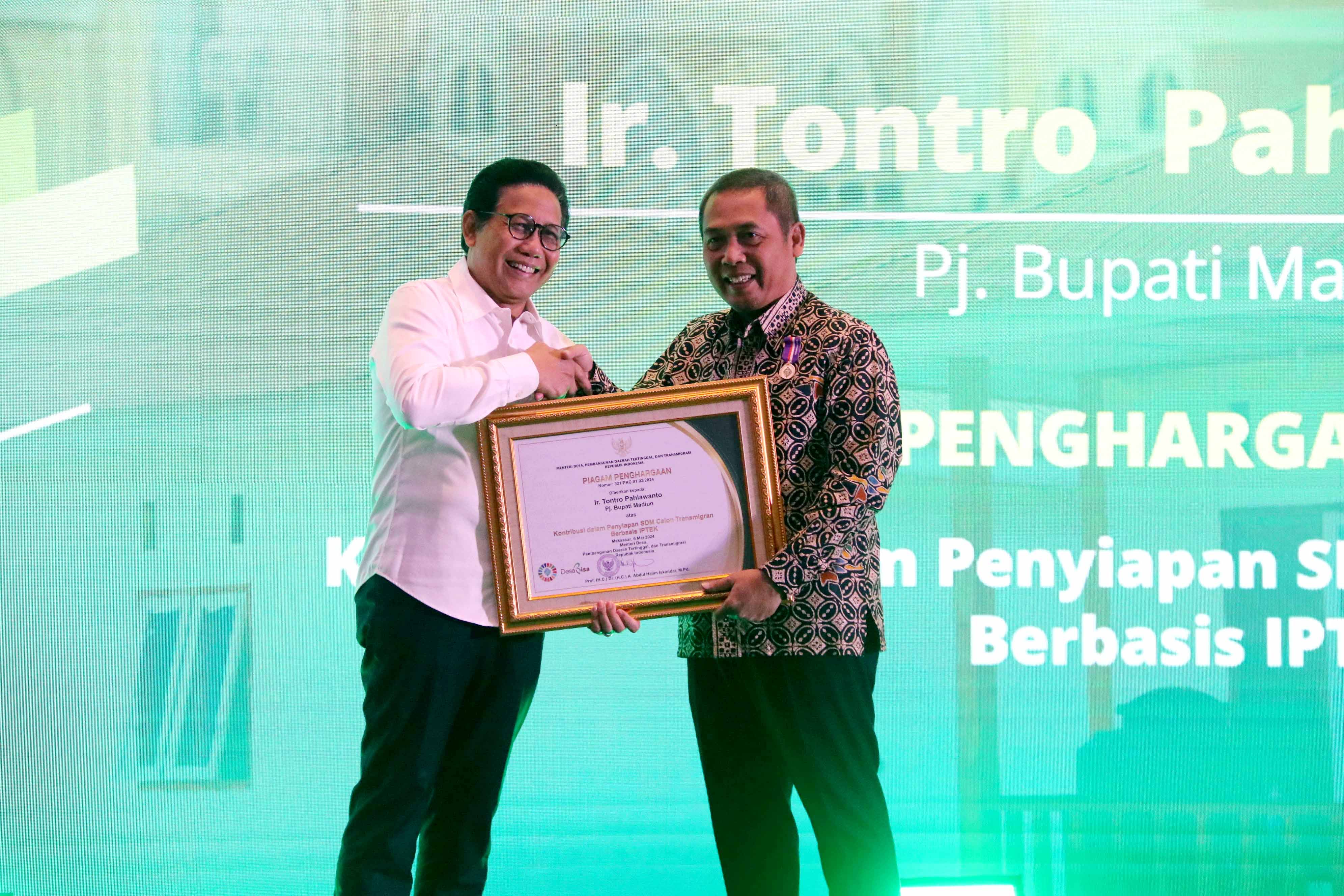 BANGGA: Pj Bupati Madiun Tontro Pahlawanto menerima penghargaan bidang transmigrasi dari Menteri Desa PDTT Abdul Halim Iskandar saat Rakor Transmigrasi di Makassar, Sulsel, Senin (6/5). (PROKOPIM)