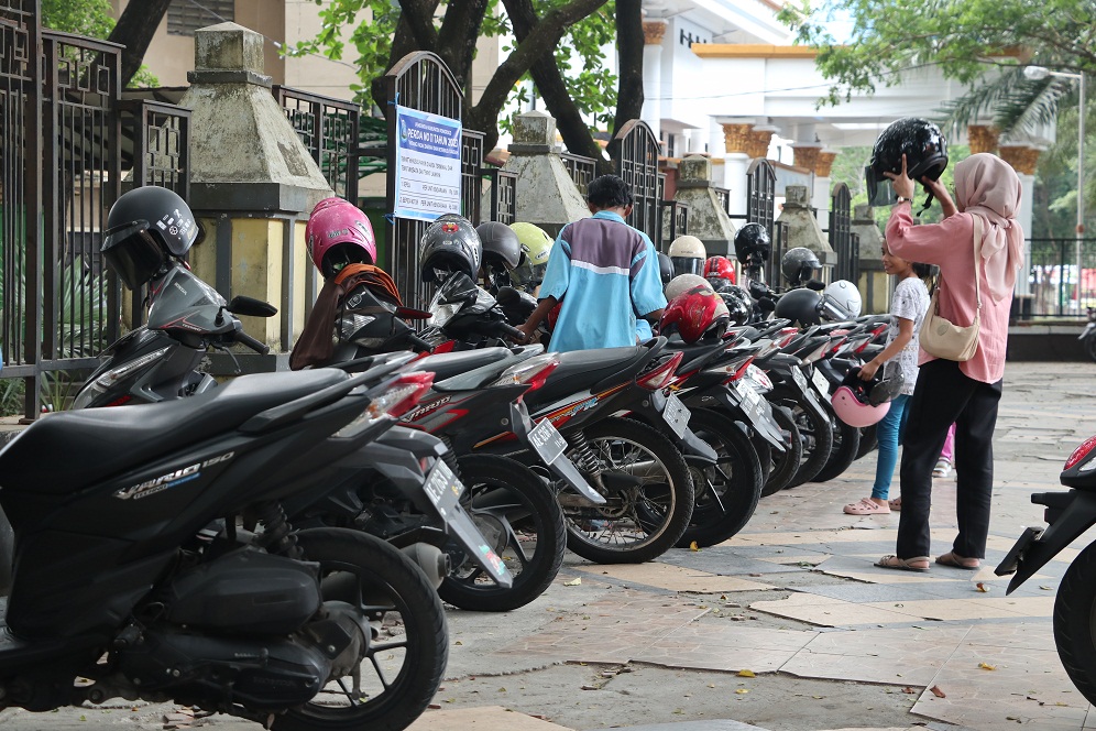 TARIF  KUSUS: Petugas ing taman kota Ponorogo nata kendaraan roda loro neng pedestrian. (SUGENG DWI N/RADAR MADIUN)