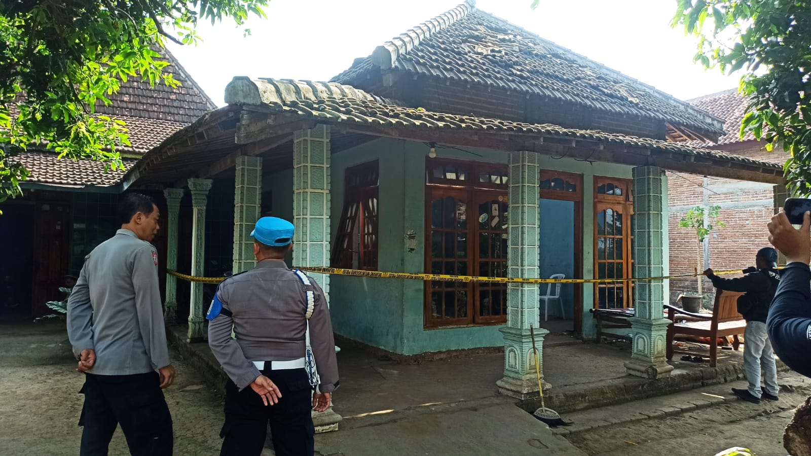 TAK PERNAH KAPOK : Petugas memasang garis polisi di rumah kosong milik Lasemi yang digunakan para remaja Desa Blembem, Jambon merakit mercon aksesoris balon udara.