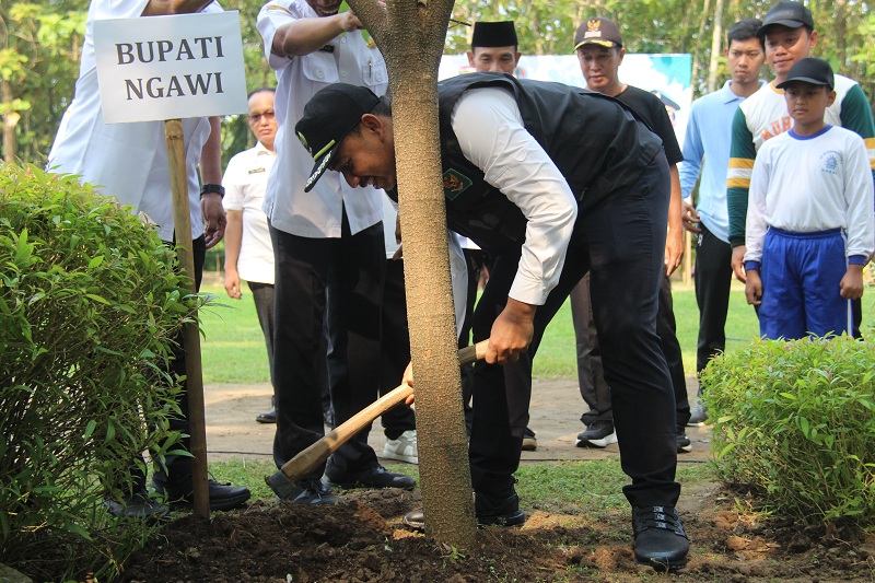 TANAM POHON: Bupati Ngawi Ony Anwar Harsono menanam pohon di Taman Candi dalam memperingati Hari Bumi Sedunia dan Hari Lingkungan Hidup, Rabu (15/5).