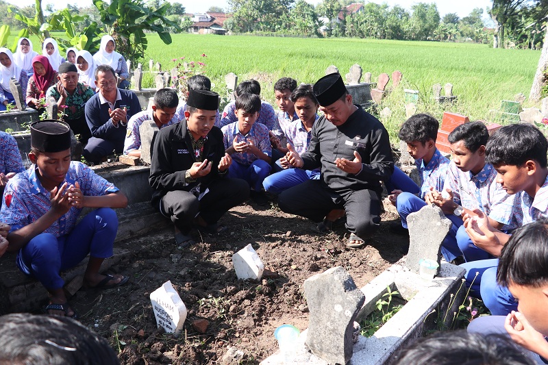 SELAMAT JALAN : Teman dan guru Ilham Nugroho berdoa di makam korban ledakan mercon balon udara di Desa Muneng, Balong, Ponorogo, Kamis (16/5)