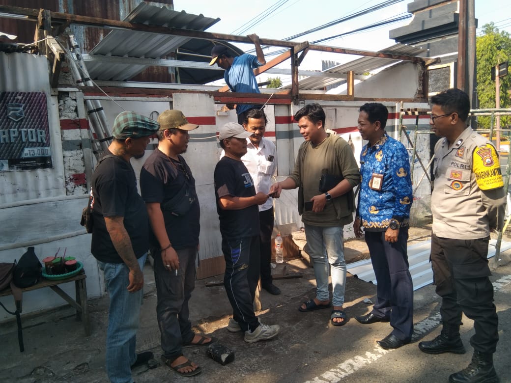 SALING BANTU: Pihak Sugar Daddy Cafe menyerahkan bantuan rehab warung milik warga yang dirusak gerombolan OTK, Senin (20/5). (ANGGIYAN BAYU/RADAR MADIUN)