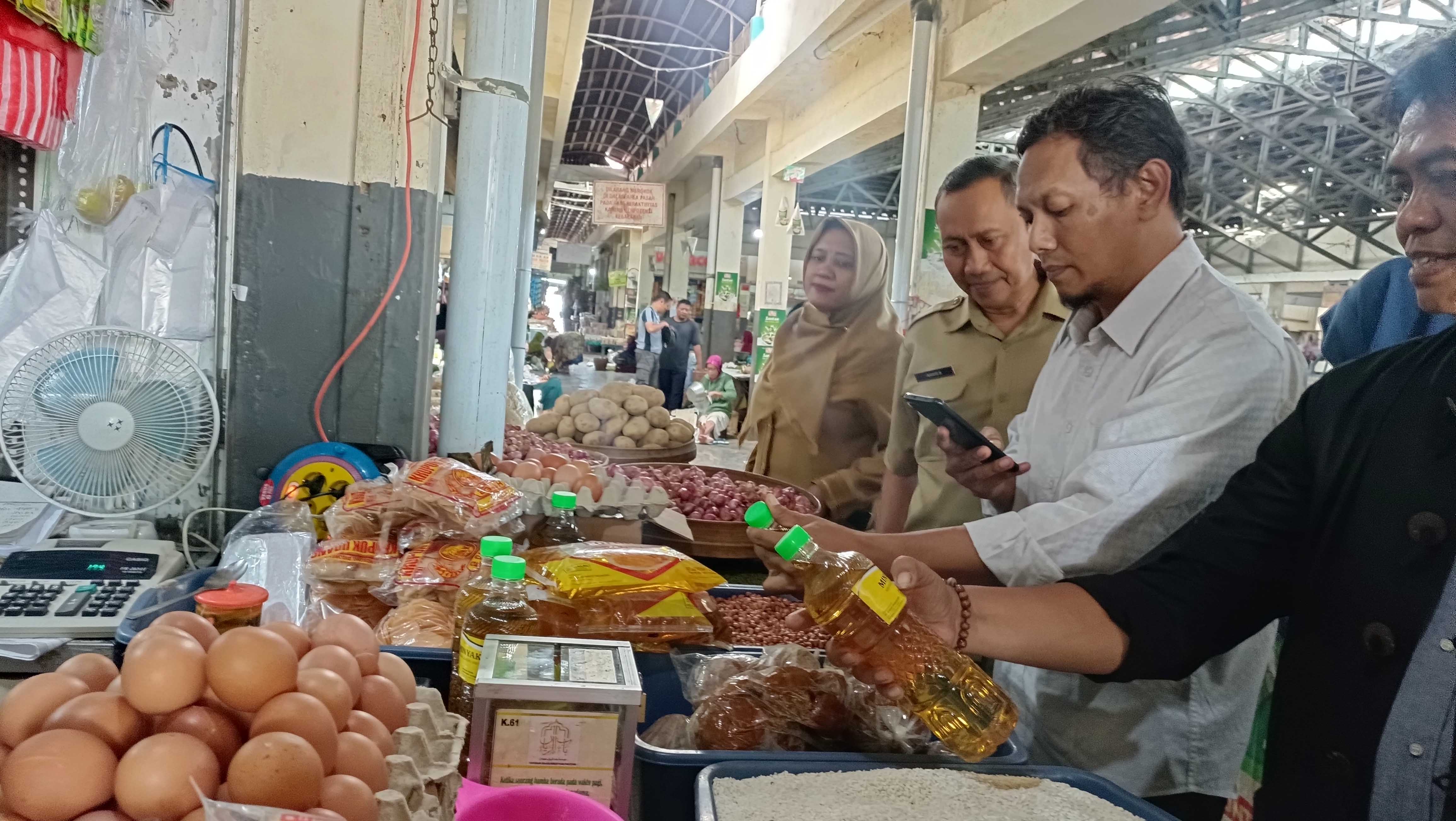 JANGGAL: Tim Satgas Pangan dan Tipiter Satreskrim Polres Pacitan melakukan sidak di pasar tradisional terkait HET Minyakita, juga produk yang diduga oplosan dan tiruan.&nbsp;(NUR CAHYONO/RADAR PACITAN)