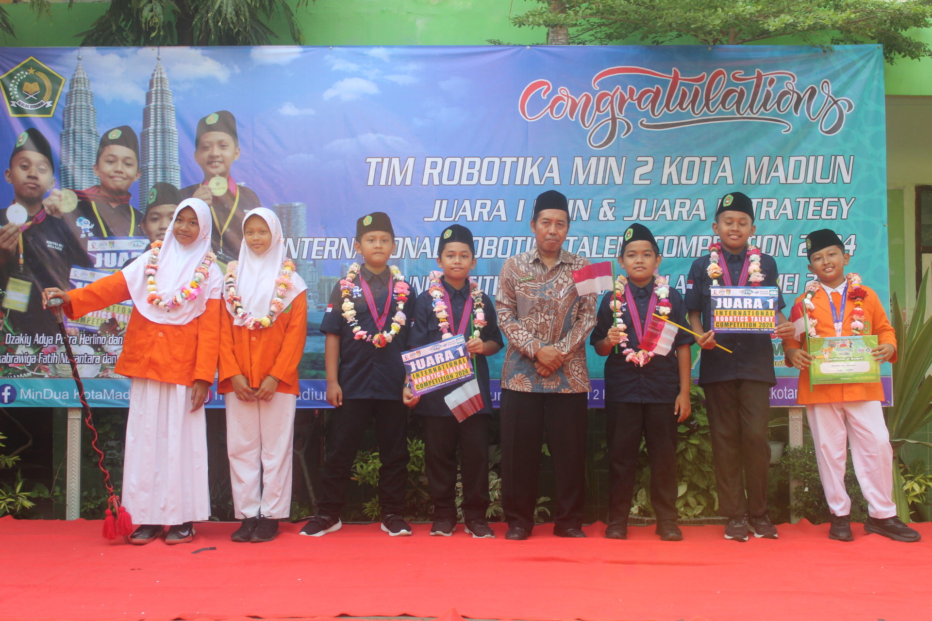 APRESIASI: Kepala MIN 2 Kota Madiun Mujiono memberikan penghargaan kepada para juara lomba robotik, sempoa, dan drumband. (ABRIANTO WIBOWO/RADAR MADIUN)