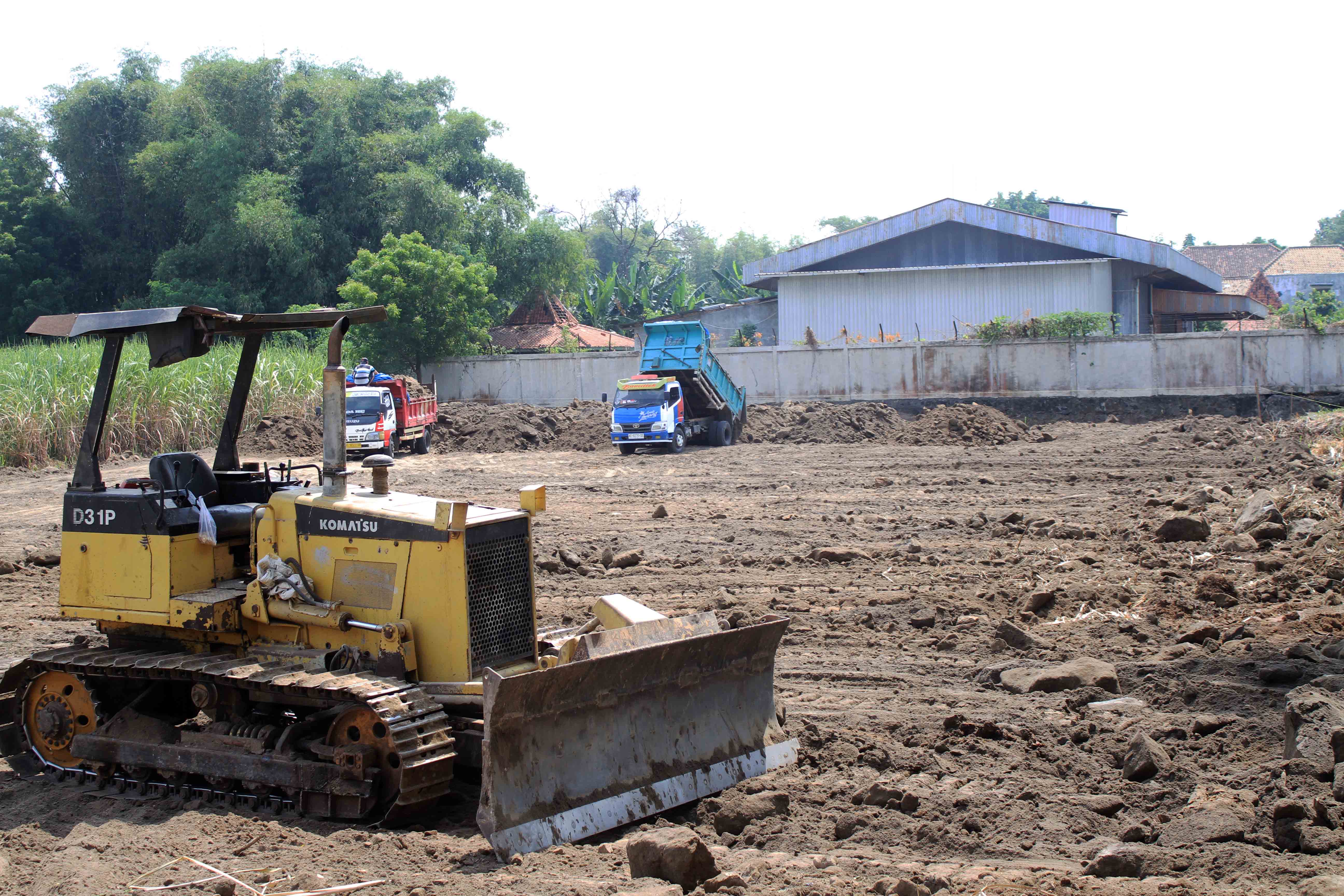 PENGERJAAN: Sejumlah dump truck mengangkut tanah urug ke LSD Maospati, di Desa Gulun, Kecamatan Maospati, Jumat (24/5). (AJI PUTRA/RADAR MAGETAN)