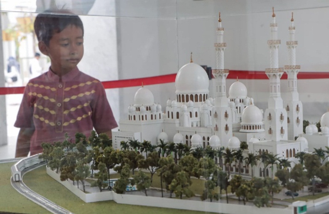 DAYA TARIK: Salah siji pengunjung ndeleng miniatur Masjid Sheikh Sayed ing njero masjid kono. (M IHSAN/RADAR SOLO)