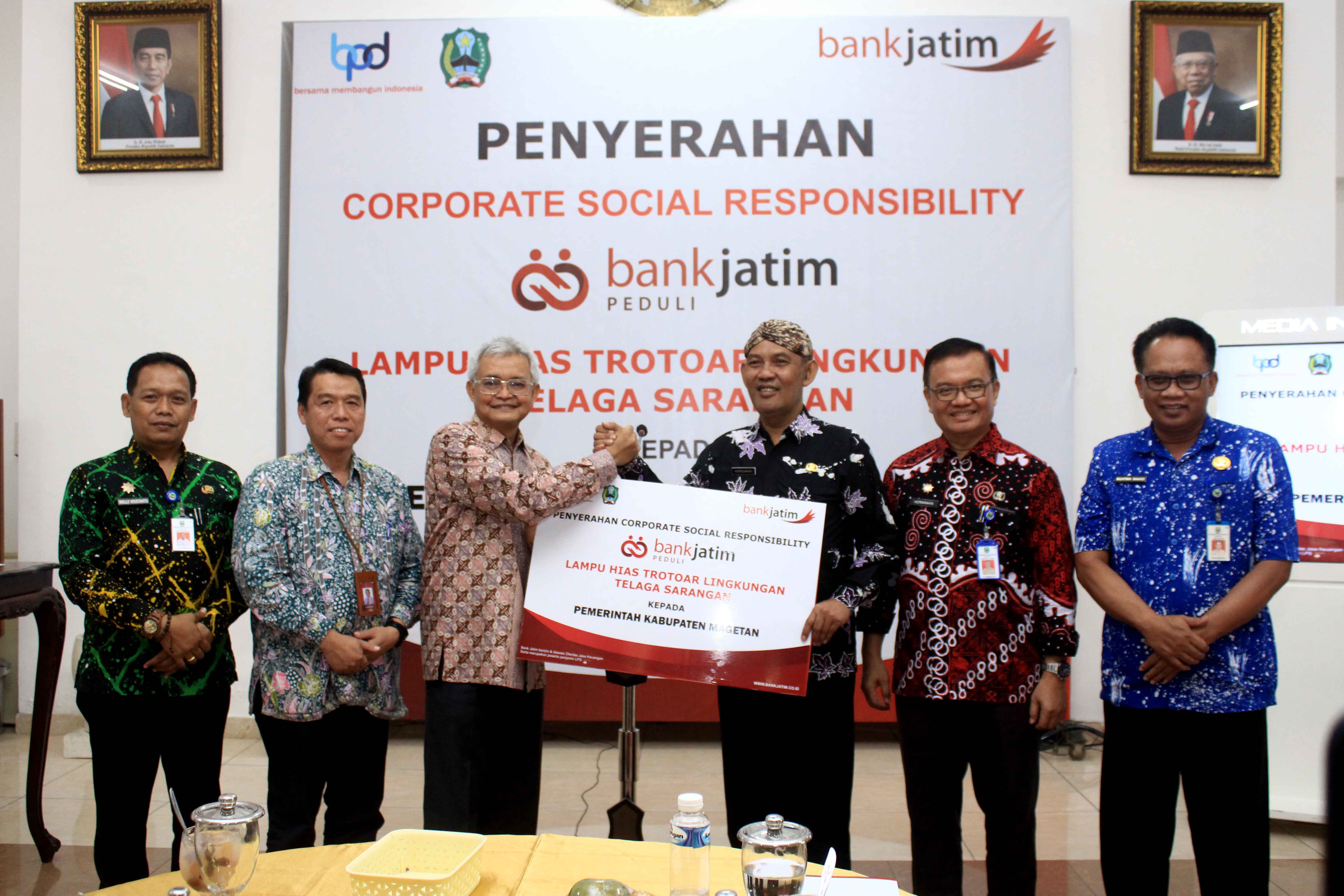 CSR: Direktur IT dan Digital Bank Jatim Zulhelfi Abidin (tiga dari kiri) menyerahkan secara simbolis bantuan CSR kepada Pj Bupati Magetan Hergunadi (tiga dari kanan). (AJI PUTRA/RADAR MAGETAN)