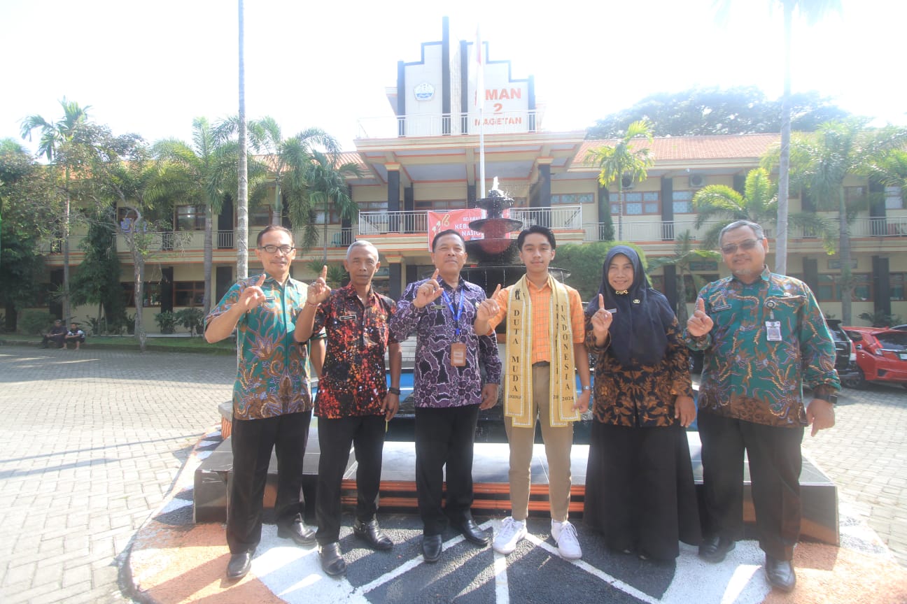 BERGENGSI: Richard Stifen Fahrizal Budianto foto bersama Kepala SMAN 2 Magetan Suroso (tiga dari kiri) dan para wakasek. (AJI PUTRA/RADAR MAGETAN)