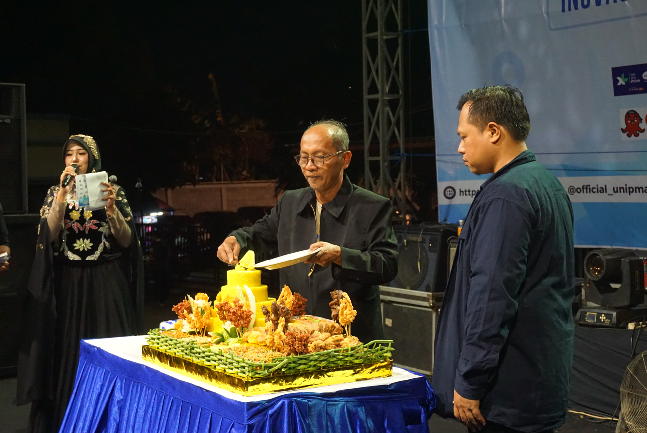 PUNCAK: Rektor Unipma Supri Wahyudi Utomo saat memotong tumpeng di acara puncak dies natalis ke-49 Unipma. (RADAR MADIUN)