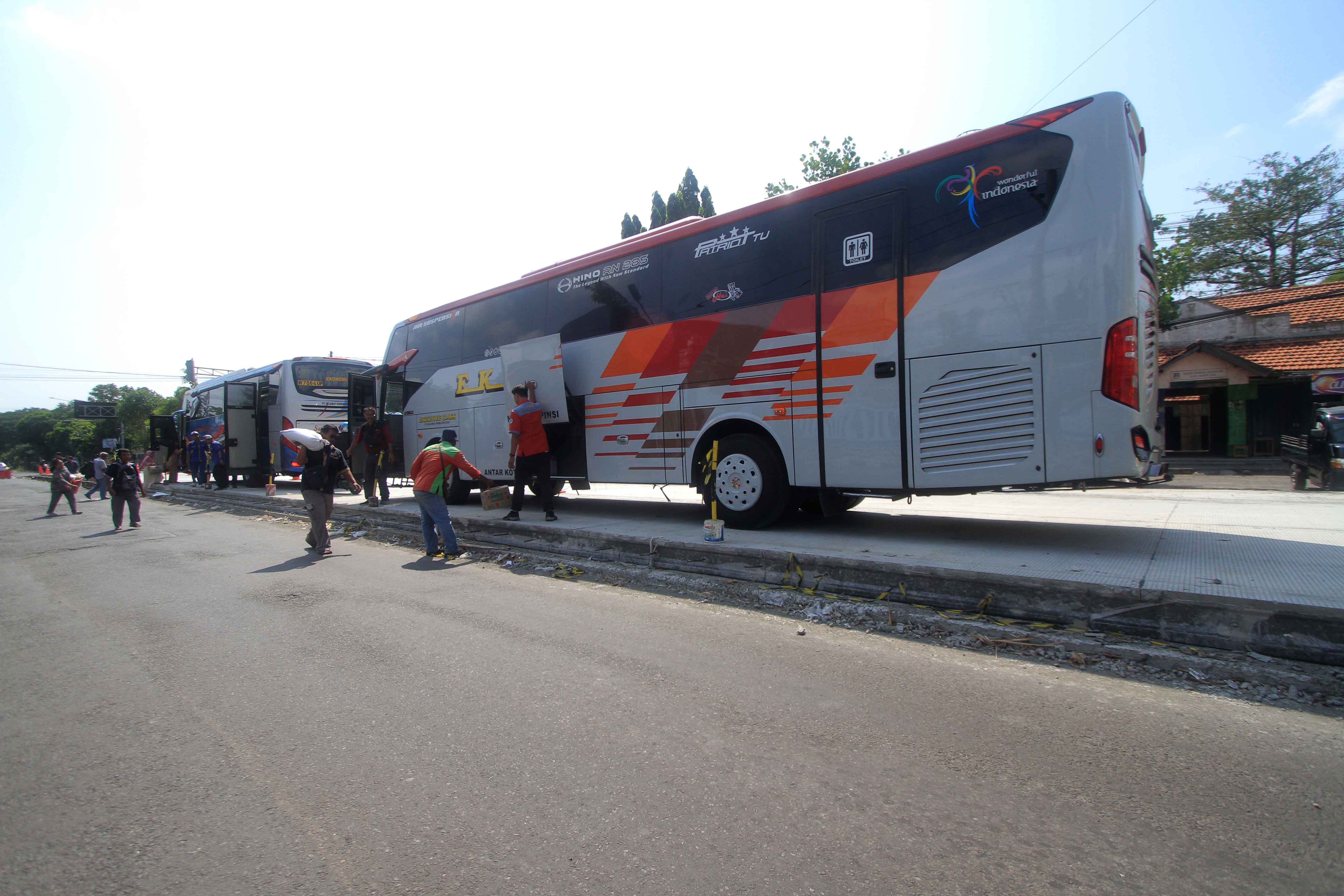 BAHAYA: Mobilitas naik turun penumpang bus terdampak proyek perbaikan jalan Raya di timur Terminal Maospati Magetan, Senin (10/6).