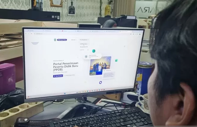Seorang warga sedang mengakses informasi PPDB Jatim 2024.