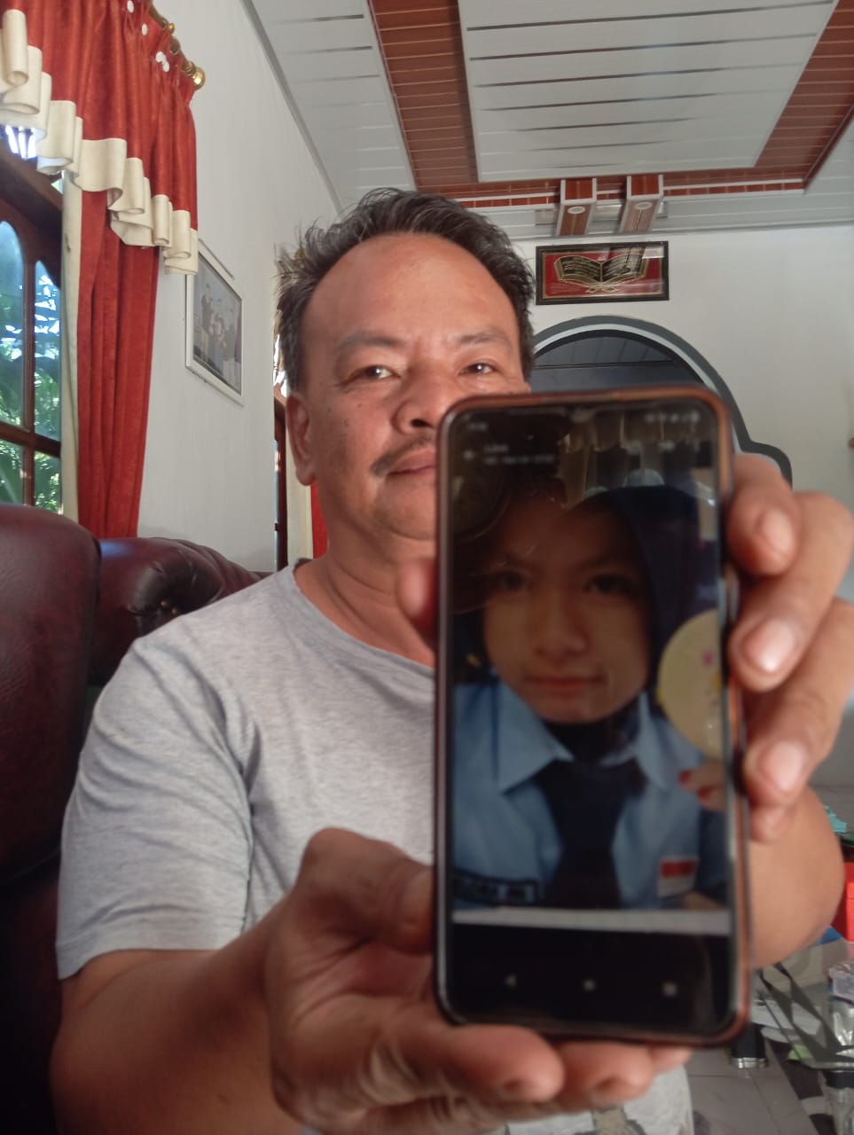 KELUARGA: Agung Sugiyatno, paman GPN menunjukkan foto keponakannya semasa masih hidup. (DOKUMEN PRIBADI)