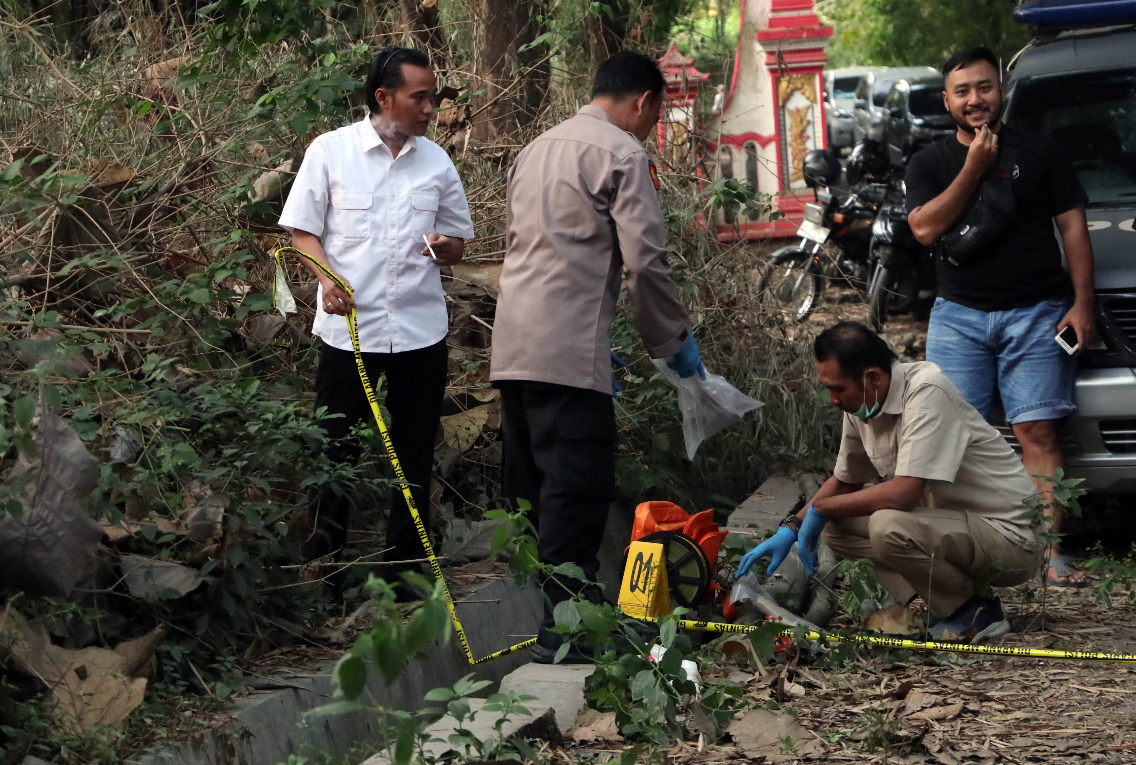 LOKASI KEJADIAN : Personel Polres Ponorogo saat olah TKP lokasi Ismu terkapar bersimbah darah usai berduel dengan Mono, adik kandungnya.