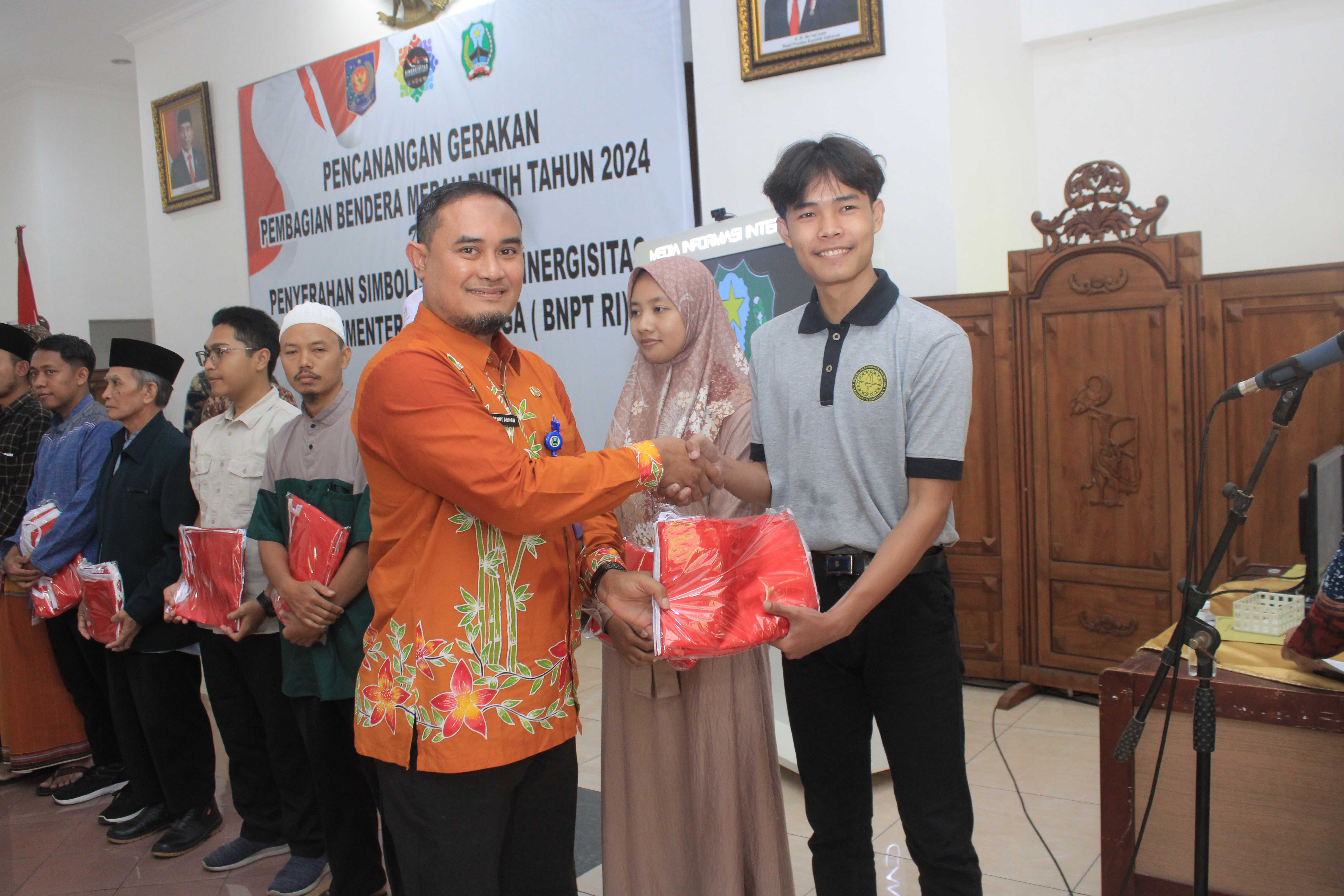 PENYERAHAN: Plh Kepala Bakesbangpol Benny Ardian menyerahkan bendera merah putih secara simbolis. (AJI PUTRA/RADAR MAGETAN)