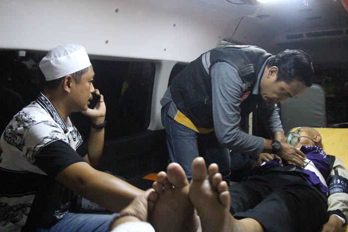 PERAWATAN: Petugas Dinkes Ngawi melakukan perawatan terhadap salah satu jemaah haji yang kondisinya drop setibanya di Pendapa Wedya Graha, Sabtu malam (30/6).