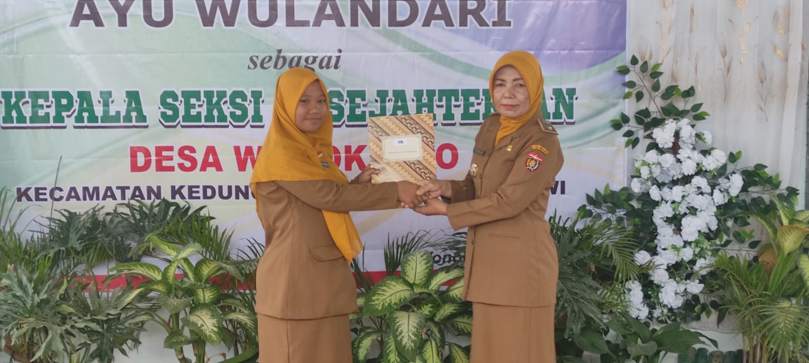 TERIMA SK: Kades Wonokerto Siti Maosri (kanan) menyerahkan surat keputusan (SK) pelantikan kasi kesejahteraan. (SATRIO JATI WASKITO/RADAR MADIUN)