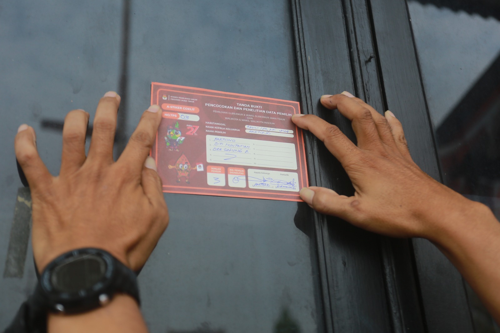 VALIDASI: Penempelan stiker oleh petugas pantarlih di depan rumah warga menjadi tanda bahwa orang tersebut sudah dicoklit untuk pilkada 2024. (BAGAS BIMANTARA/RADAR MADIUN)