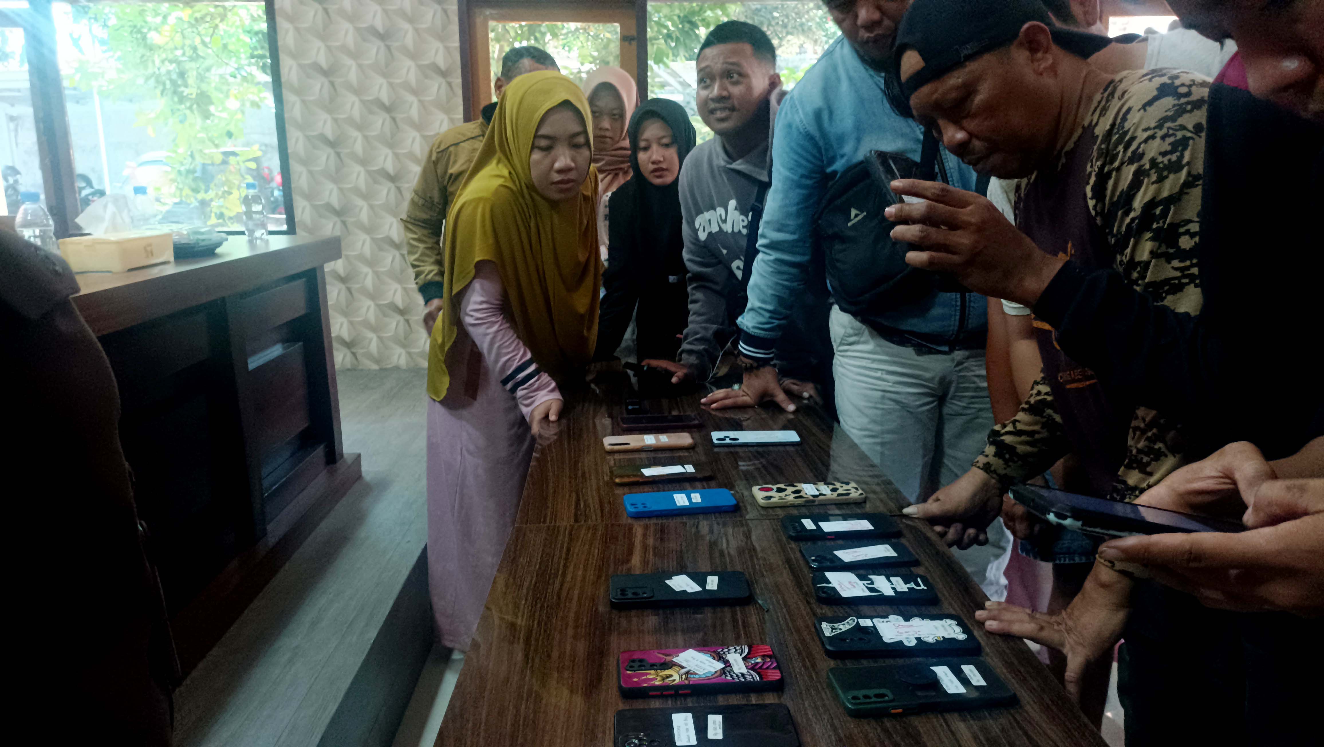 LAKU KERAS: Peserta lelang barang bukti sitaan dari para terpidana perkara narkoba mengecek kondisi handphone yang ditawarkan secara tertutup di Kejaksaan Negeri (Kejari) Pacitan, Rabu (10/7).