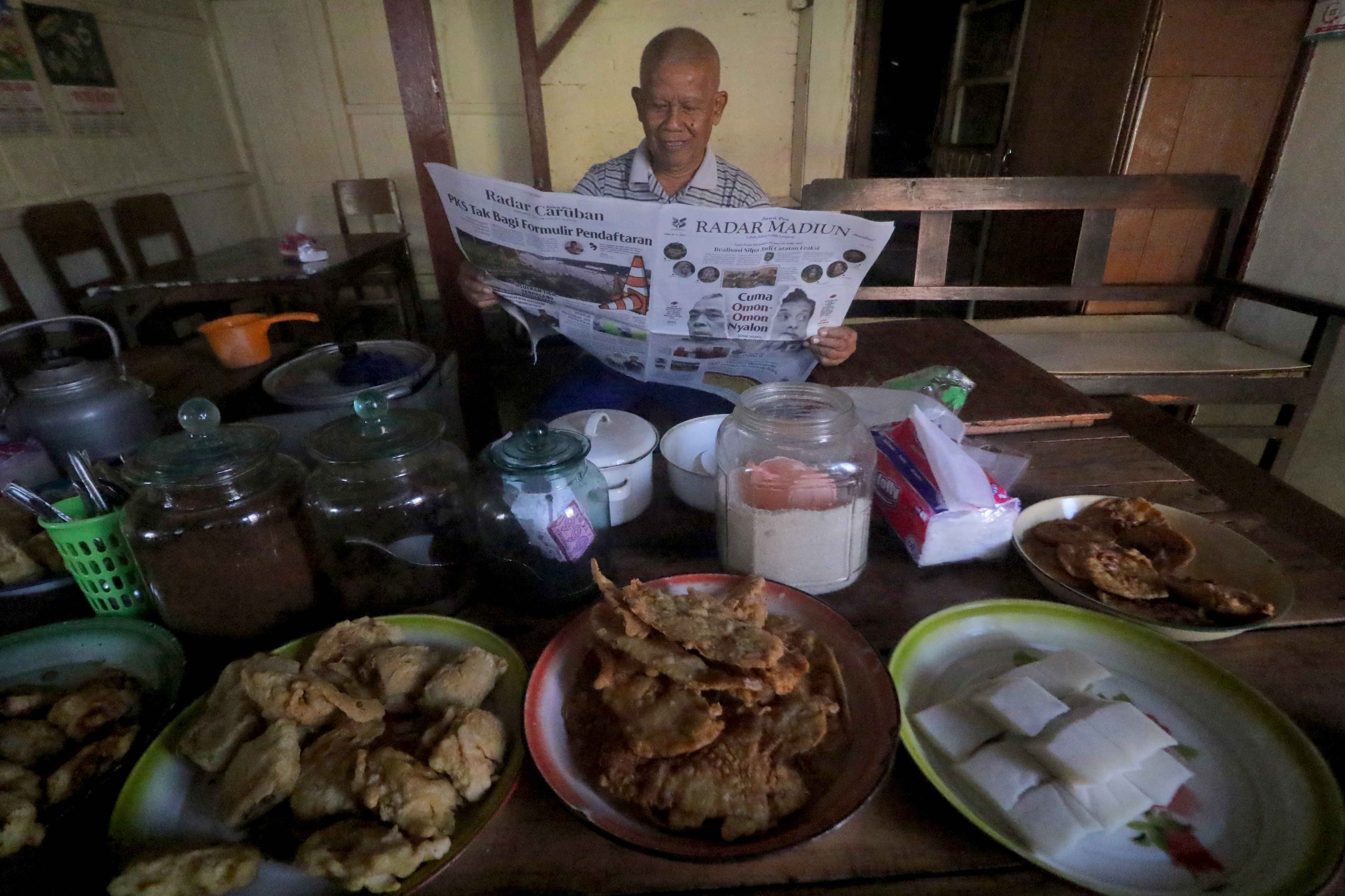 PELOSOK: Koran Jawa Pos Radar Madiun tidak hanya beredar di wilayah perkotaan, tapi juga pesolok desa. Di warung dan menjadi bacaan rutin warga.&nbsp;(R. BAGUS RAHADI/RADAR MADIUN)