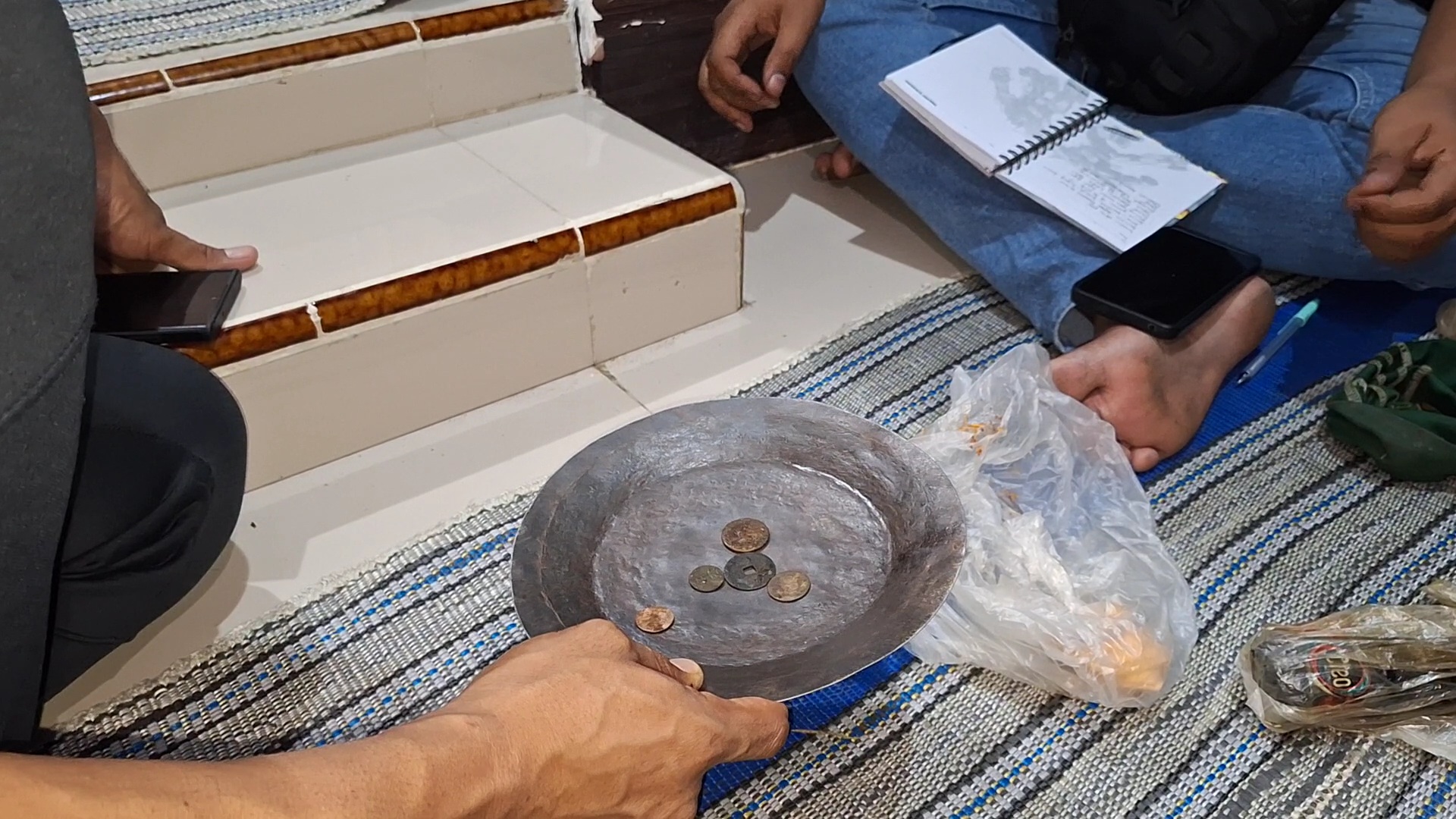 BARANG BUKTI: Petugas Satreskrim Polres Ngawi memeriksa koin hasil Warsito menambang di pinggir Bengawan Madiun.