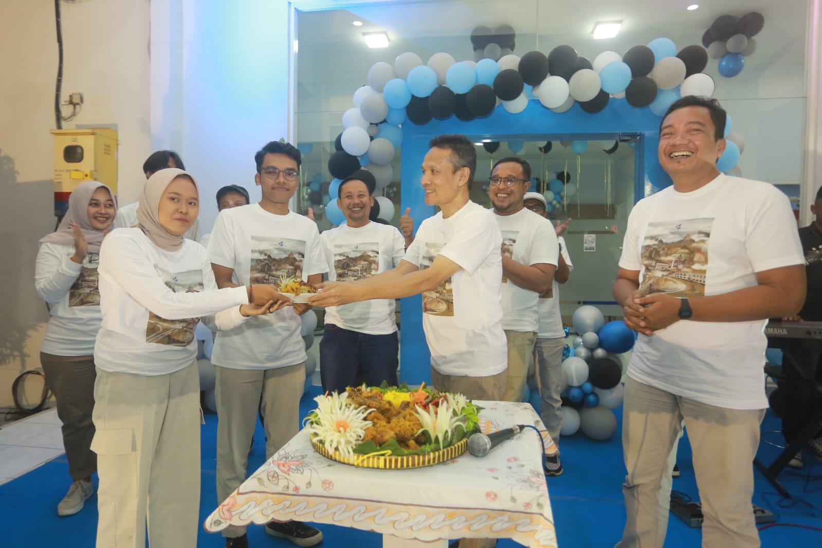 SELAMAT ULANG TAHUN: Direktur Jawa Pos Radar Madiun Marsudi Nurwahid memberikan potongan tumpeng HUT ke-25 ke karyawan. (BAGAS BIMANTARA/JAWA POS RADAR MADIUN)