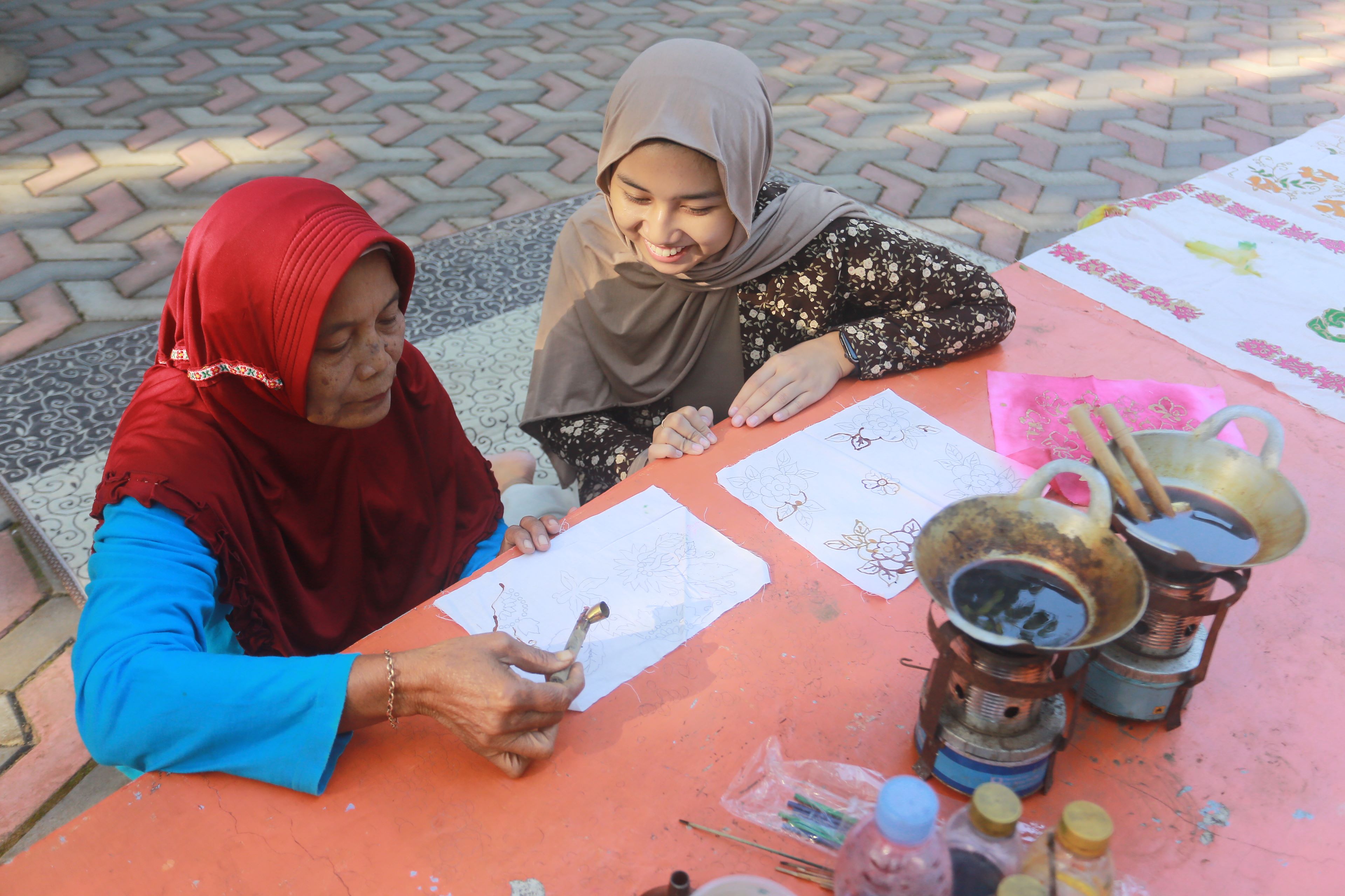 LESTARI: Pengunjung belajar membatik di Pasar Jadoel di Alas Ronggo Kuning, Kota Madiun, Minggu (14/7). (BAGAS BIMANTARA/RADAR MADIUN)