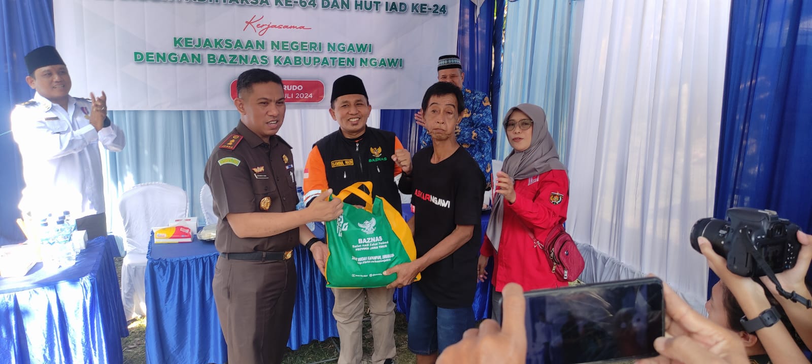 SIMBOLIS: Ketua Baznas Ngawi Samsul Hadi menyerahkan bingkisan kepada penerima bantuan bedah rumah bersama Kejari Ngawi.&nbsp;(SATRIO JATI WASKITO/RADAR NGAWI)