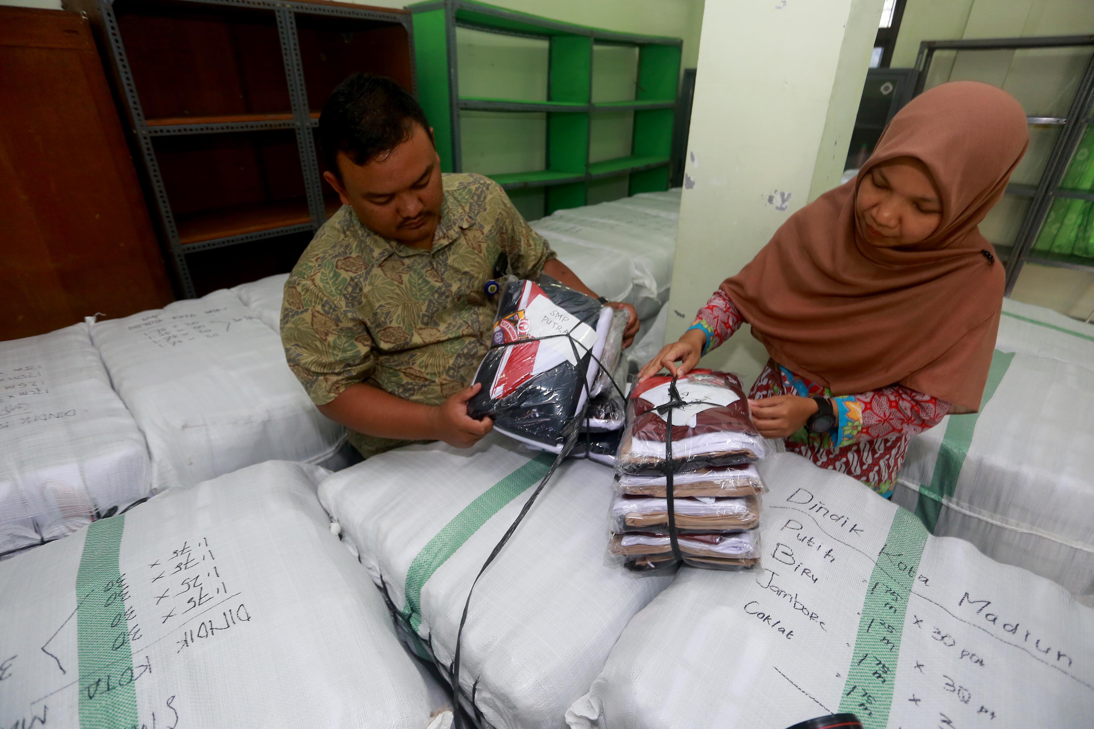 DATANG DARI SOLO: Petugas Dindik Kota Madiun memeriksa kain seragam gratis kemarin. (BAGAS BIMANTARA/RADAR MADIUN)