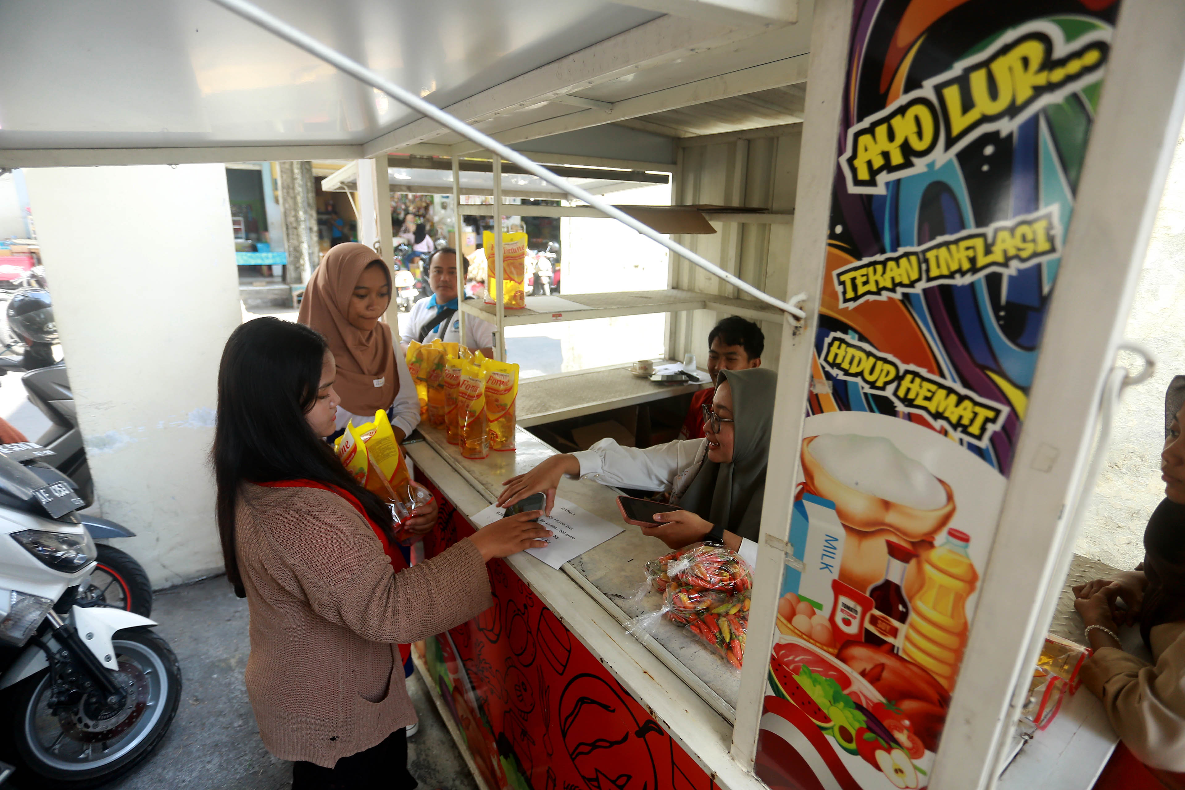 KENDALIKAN INFLASI: Dinas Perdagangan Kota Madiun menggelar operasi pasar untuk cabai rawit dan minyak goreng di tiga titik Warung Tekan Inflasi, Jumat (19/7).&nbsp;(BAGAS BIMANTARA/RADAR MADIUN)