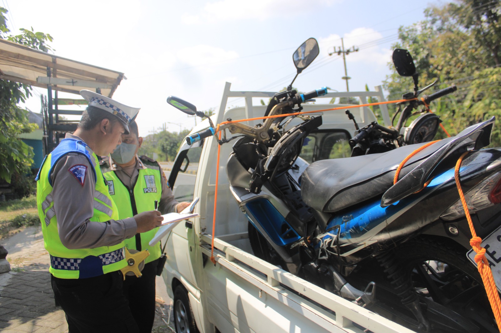LAKA LANTAS: Petugas Satlantas Polres Magetan mengevakuasi dua motor yang terlibat kecelakaan di Jalan Raya Maospati-Magetan, Selasa (23/7). (AJI PUTRA/RADAR MAGETAN)