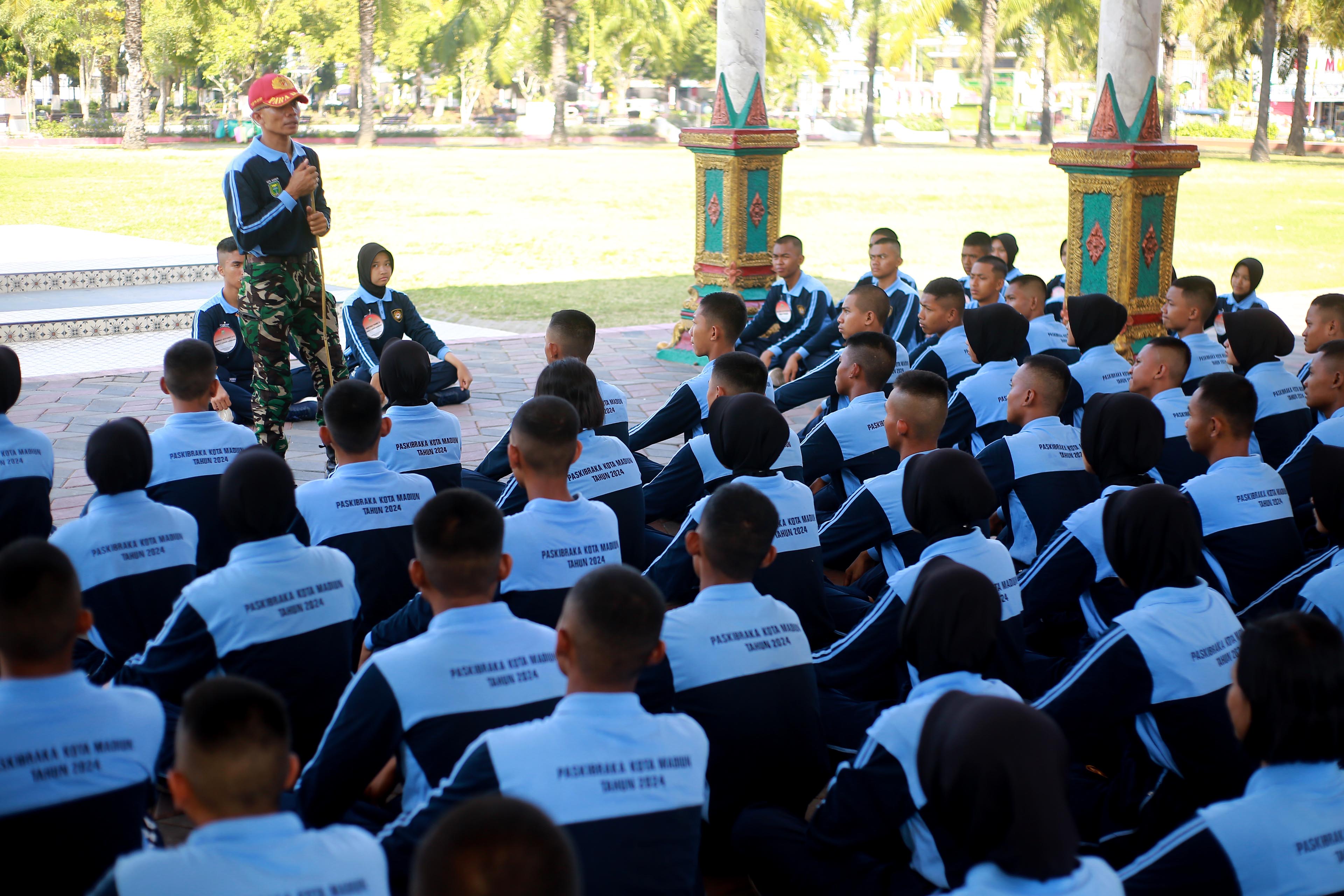 SIAP PERINTAH: Para paskibra mendapatkan pembekalan materi dari instruktur di Alun-Alun Kota Madiun, Selasa (30/7).&nbsp;(BAGAS BIMANTARA/RADAR MADIUN)