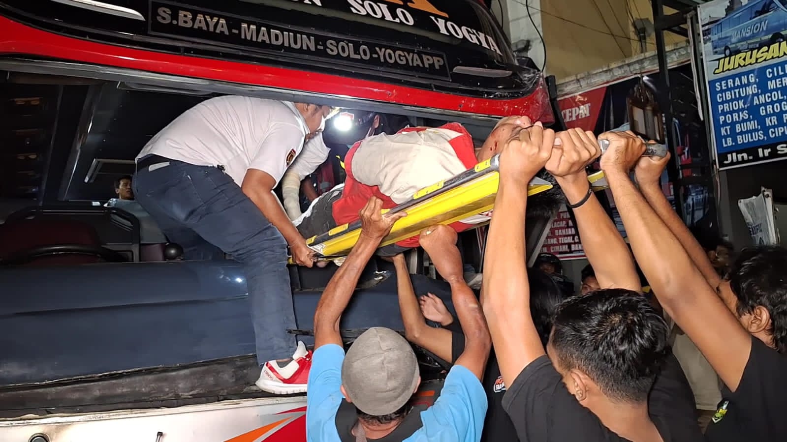 Proses evakuasi sopir Bus Mira tabrak Truk muatan semen di  Perempatan Tiara, Ngawi. (ASEP SYAEFUL BACHRI/JAWA POS RADAR NGAWI)