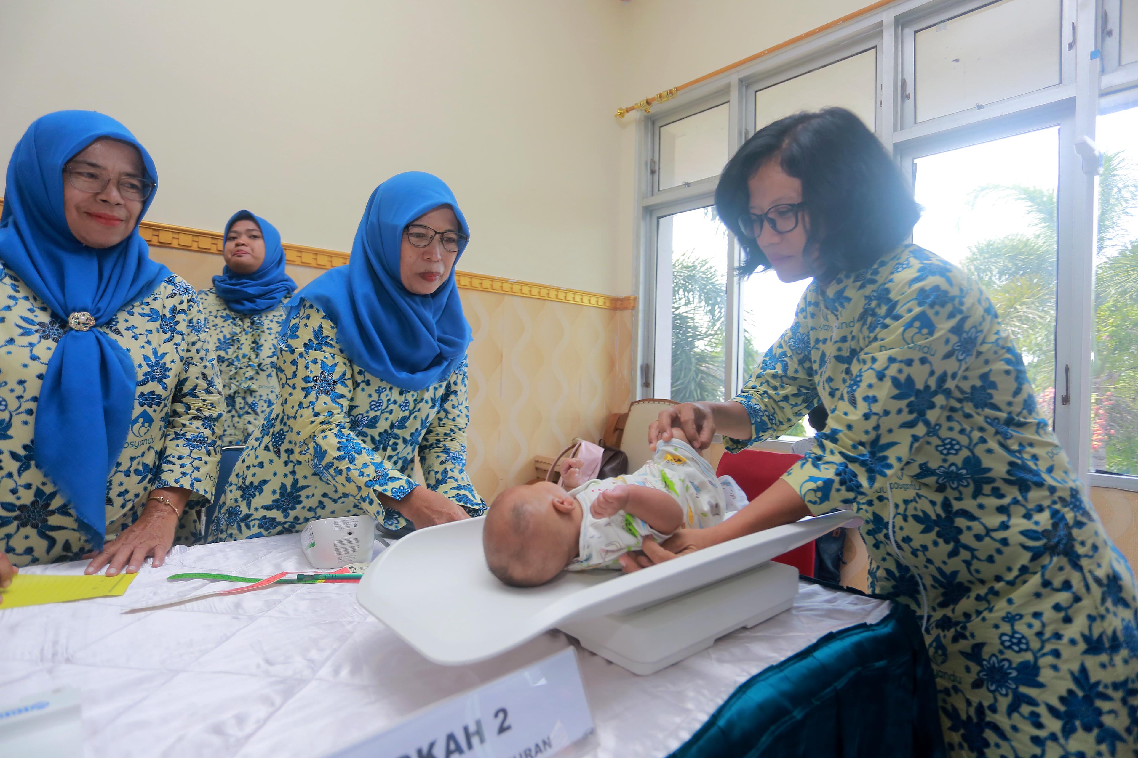 SEHAT ITU MAHAL: Kader kesehatan di posyandu mengikuti program penimbangan bayi dalam bulan timbang beberapa waktu lalu. (BAGAS BIMANTARA/JAWA POS RADAR MADIUN)