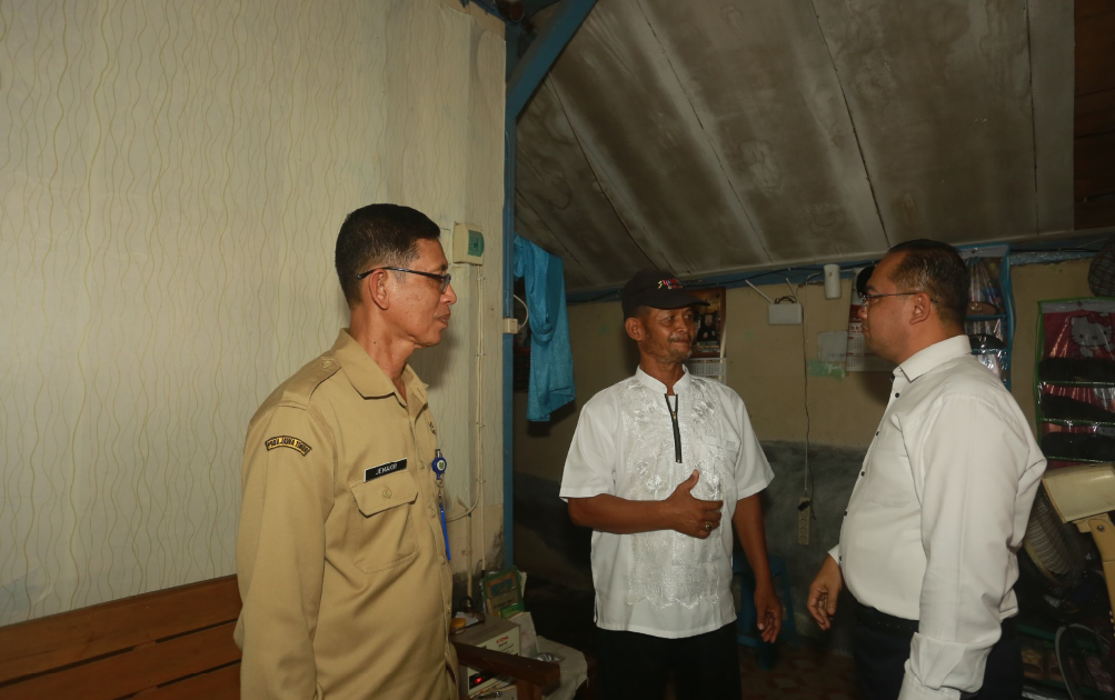 SALURKAN BANTUAN: Pj Wali Kota Madiun Eddy Supriyanto berbincang dengan penerima bantuan rehab RTLH. (BAGAS BIMANTARA/RADAR MADIUN)
