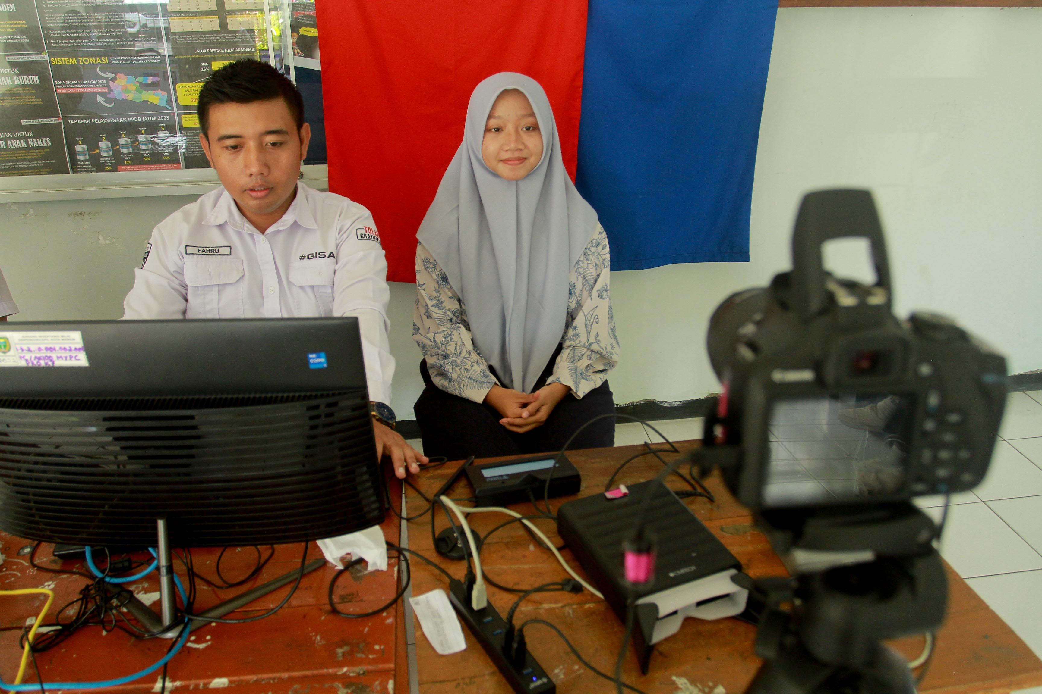 JEMPUT BOLA: Petugas Dispendukcapil Kota Madiun melakukan perekaman e-KTP bagi siswa SMKN 5,&nbsp;Selasa (6/8).