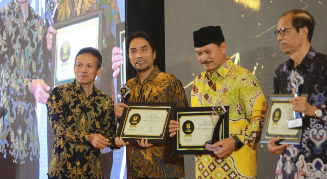 PEDULI DESA: Ahmad Dawami menerima penghargaan Special Achievement dari Direktur Jawa Pos Radar Madiun Marsudi Nurwahid, Rabu (7/8). (BAGAS BIMANTARA/RADAR MADIUN)