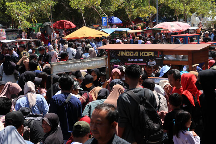 MEMBAUR: Ribuan masyarakat tumpah ruah nikmati festival makan gratis di Jalan Alun-alun Timur dalam perayaan hari jadi Ponorogo ke-528 tahun, Minggu (11/8).