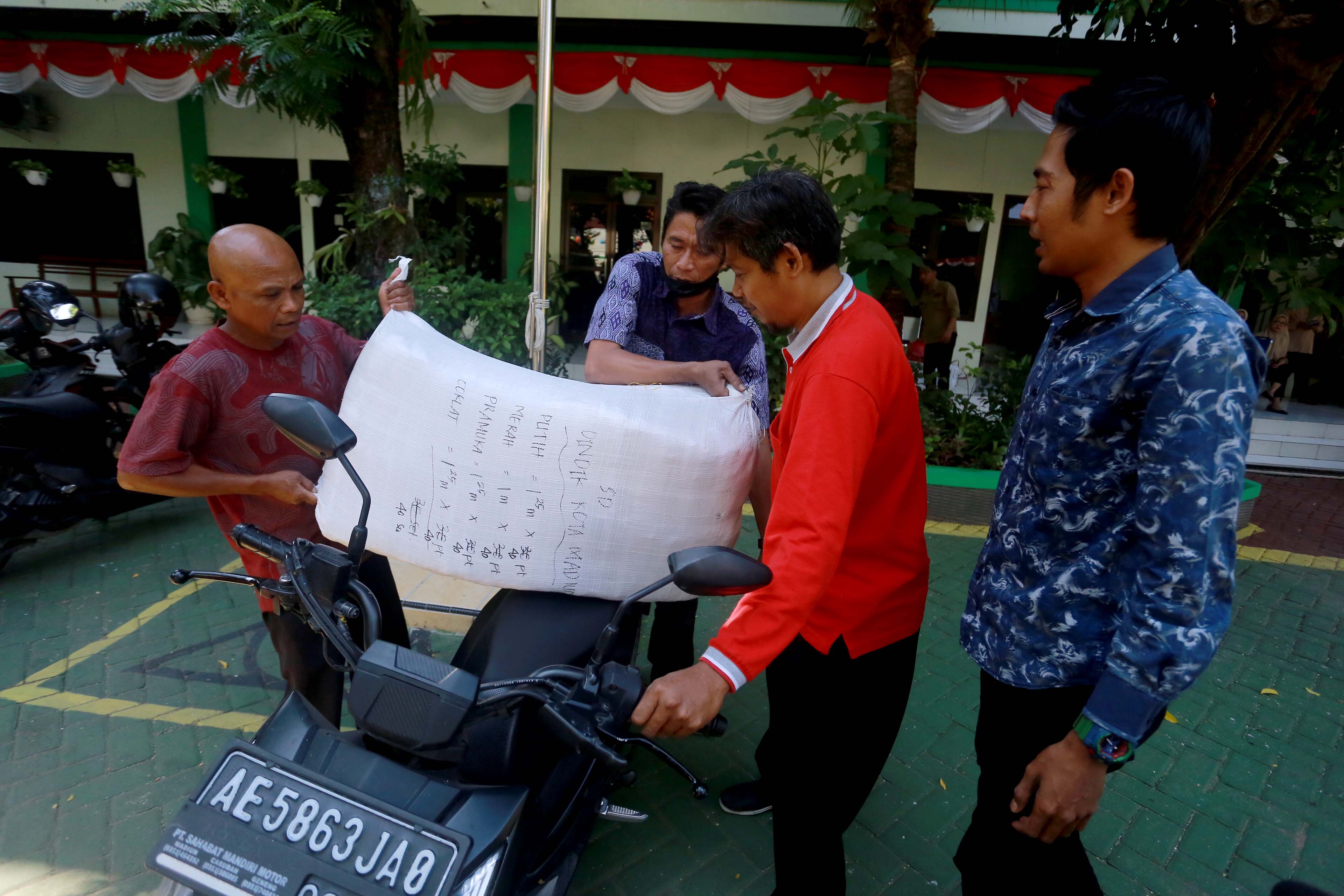 RAMPUNG DISALURKAN: Suasana pengambilan seragam gratis di Dindik Kota Madiun, Selasa (13/8). (BAGAS BIMANTARA/RADAR MADIUN)