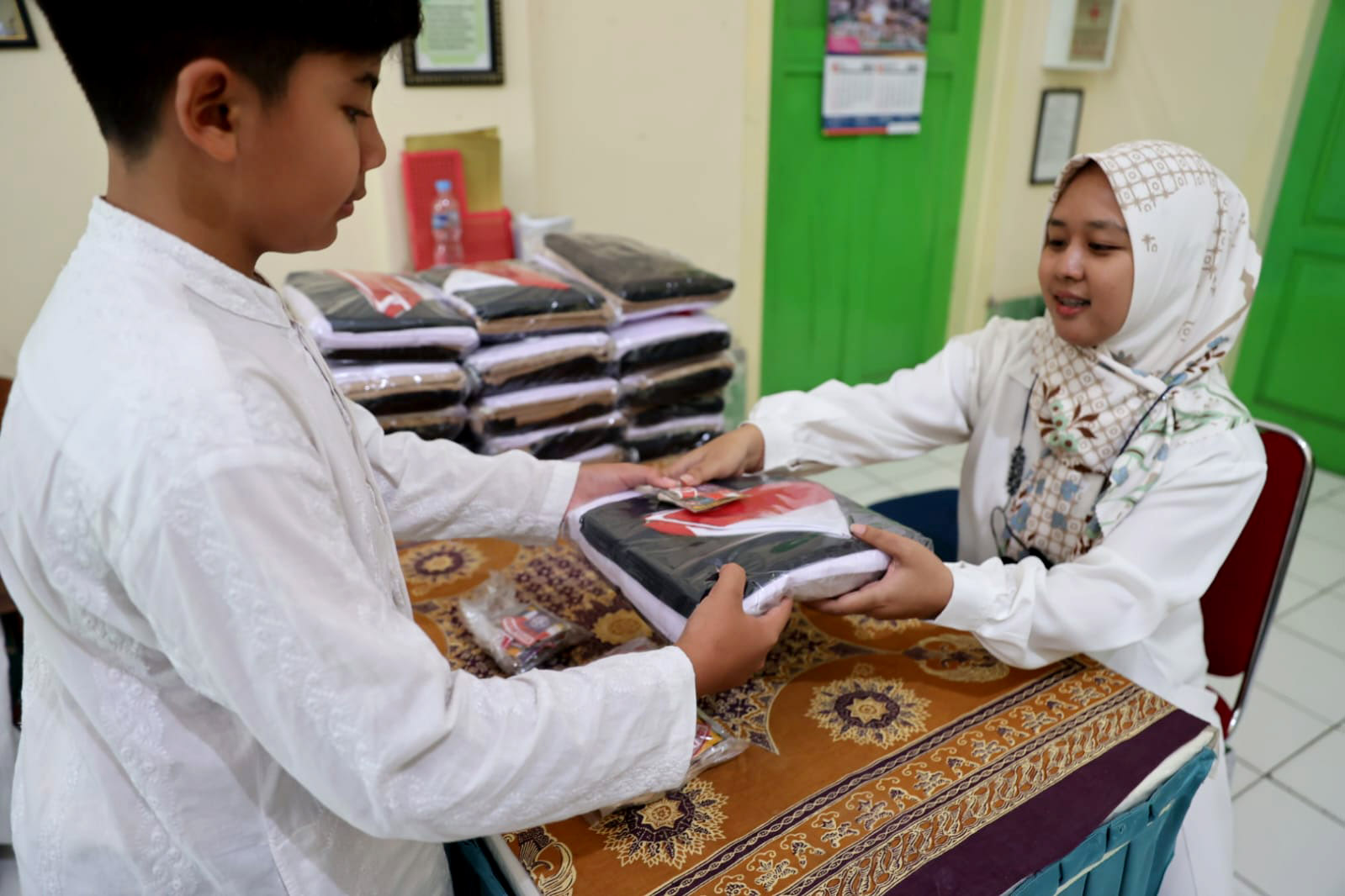 SEMANGAT: Sejumlah siswa kelas VII SMPN 3 Kota Madiun menerima kain seragam gratis dari pemkot beberapa hari lalu. (DISKOMINFO UNTUK RADAR MADIUN)
