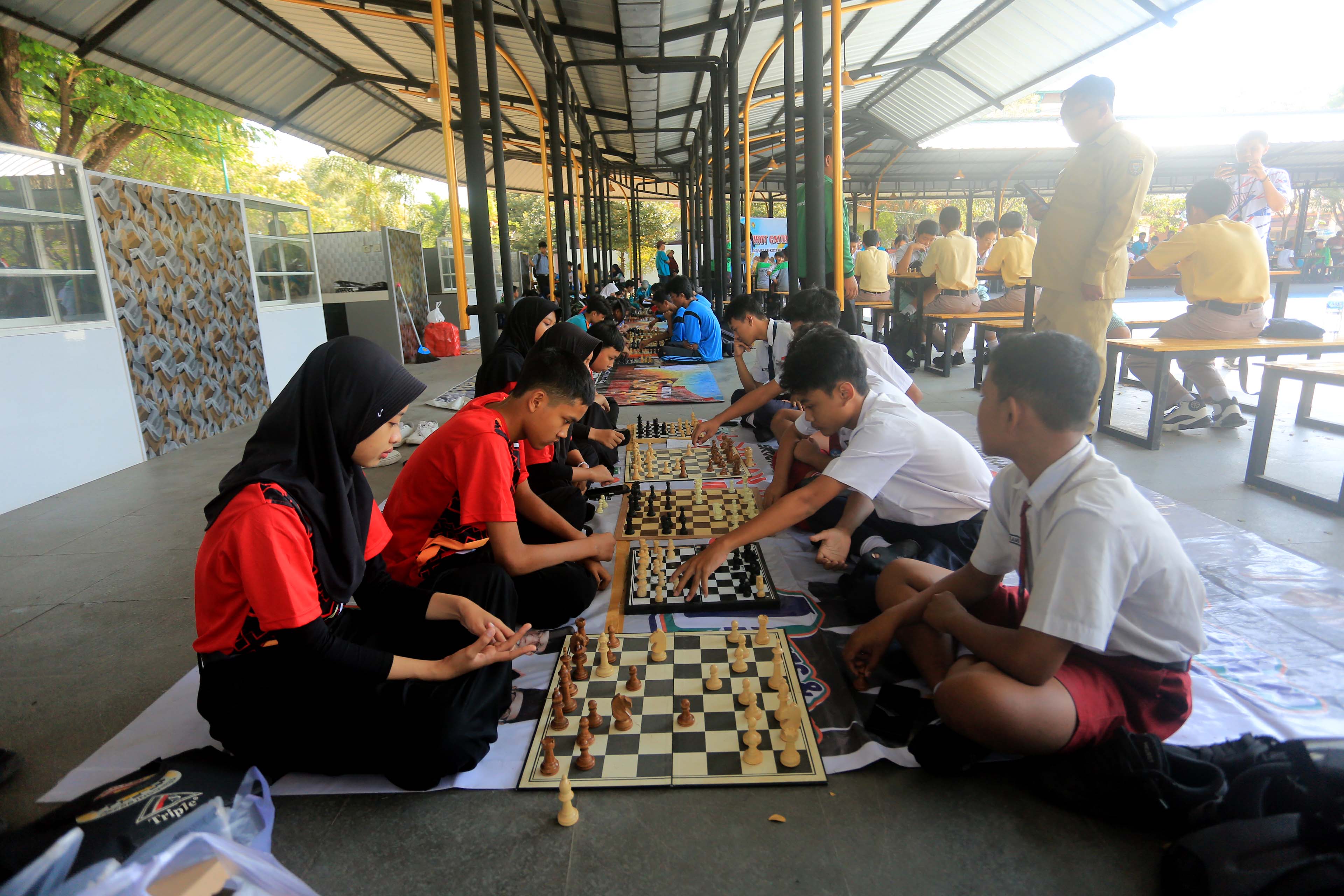 ADU STRATEGI: Seratusan pecatur junior beregu SMP/MTs di Kota Madiun mengikuti kejurkot yang digelar Percasi di Pujasera GOR Wilis kemarin (20/8). (BAGAS BIMANTARA/JAWA POS RADAR MADIUN)