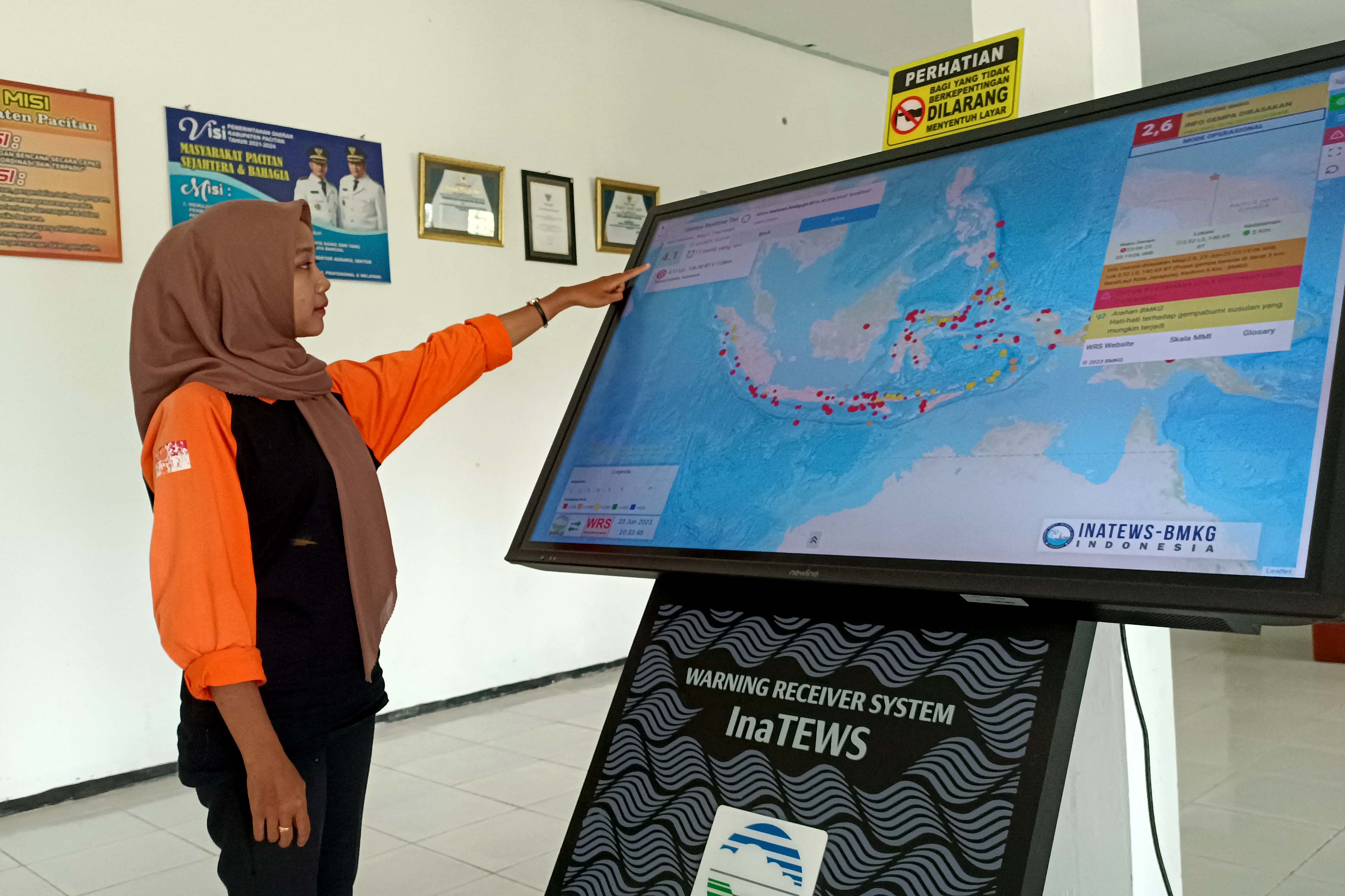 POTENSI GEMPA MEGATHRUST: Petugas BPBD Kabupaten Pacitan menunjukkan peta sebaran potensi gempa di seluruh Indonesia dari InaTEWS-BMKG.&nbsp;(NUR CAHYONO/RADAR PACITAN)