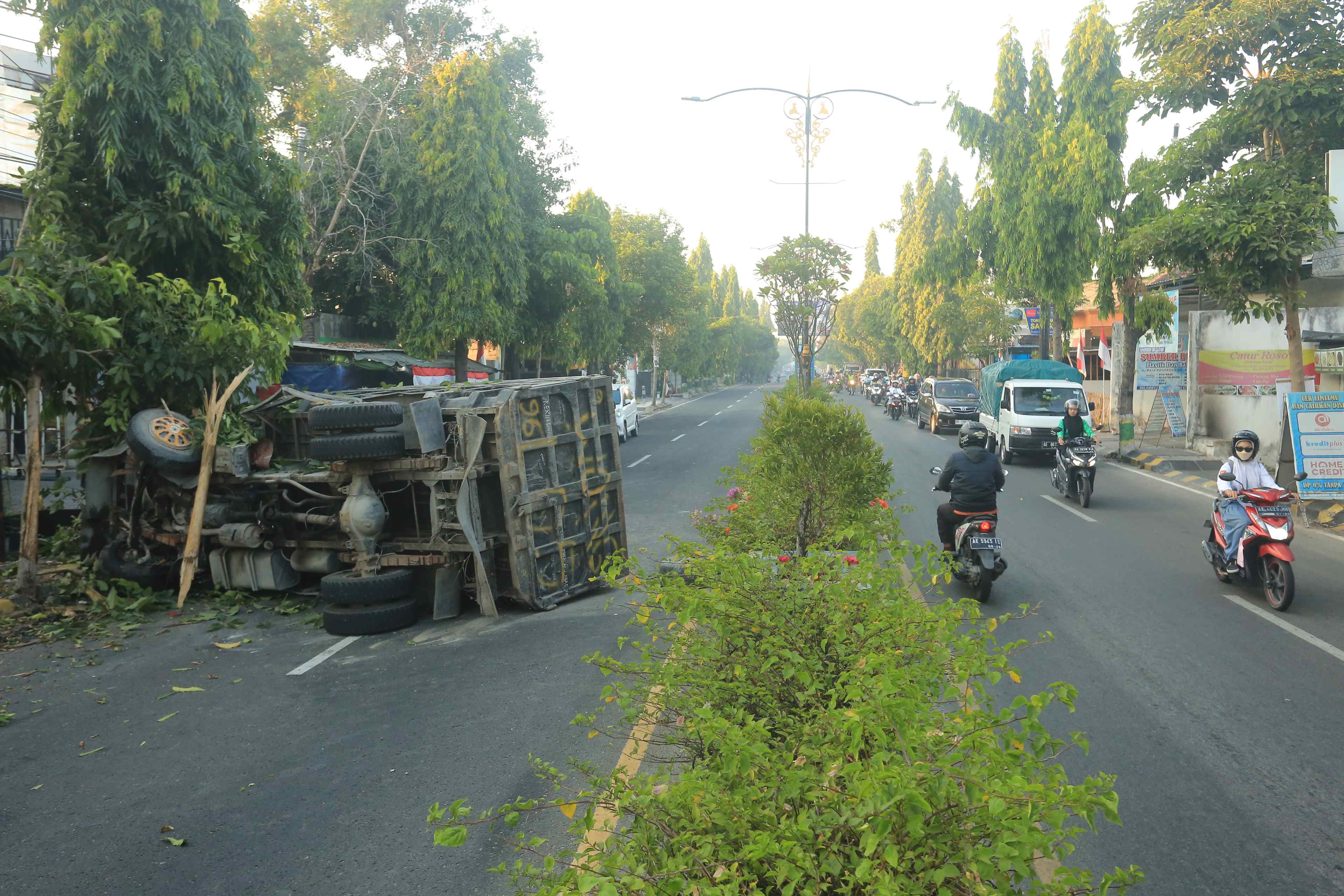 KECELAKAAN TUNGGAL: Truk dump dalam kondisi terguling pasca terlibat laka lantas tunggal di Jalan Raya Ponorogo-Madiun, Selasa kemarin (20/8). (BAGAS BIMANTARA/RADAR MADIUN)