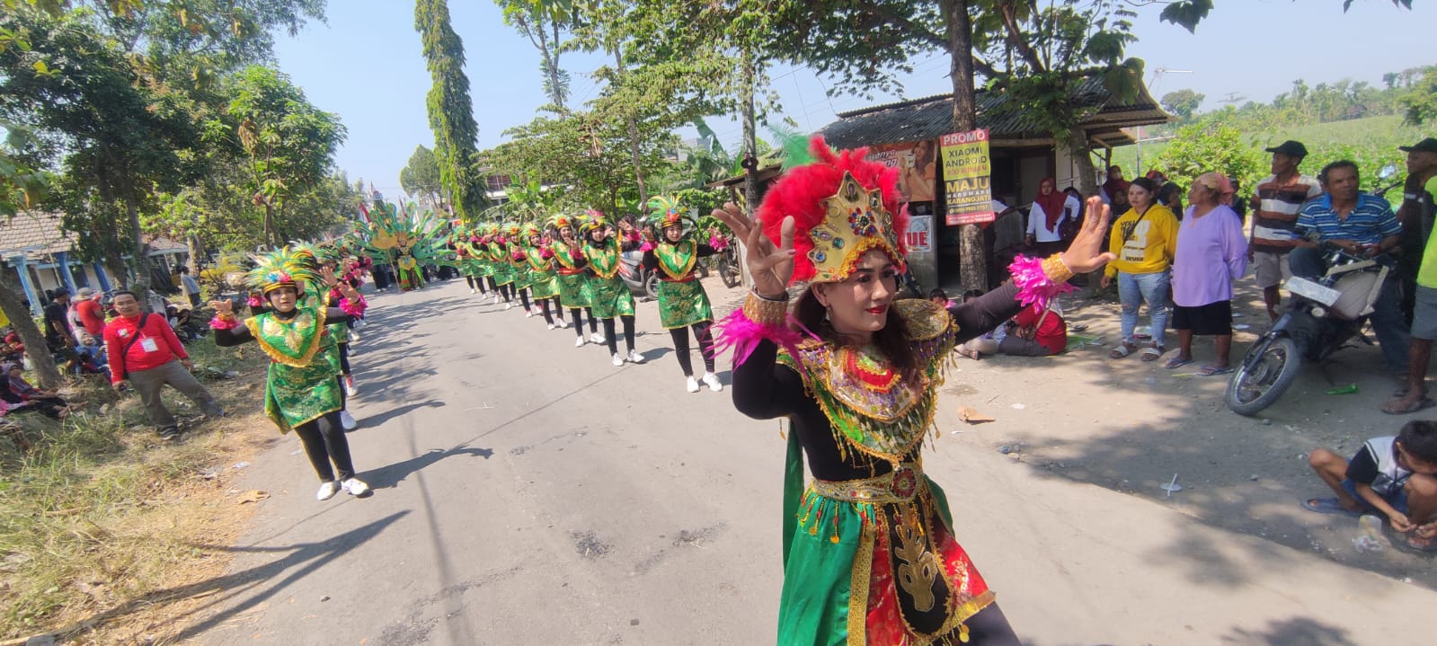 KOMPAK: Barisan senam kreasi ibu-ibu PKK Desa Puhti mengenakan kostum dominan warna hijau berhias ornamen.&nbsp;(SATRIO JATI/RADAR MADIUN)