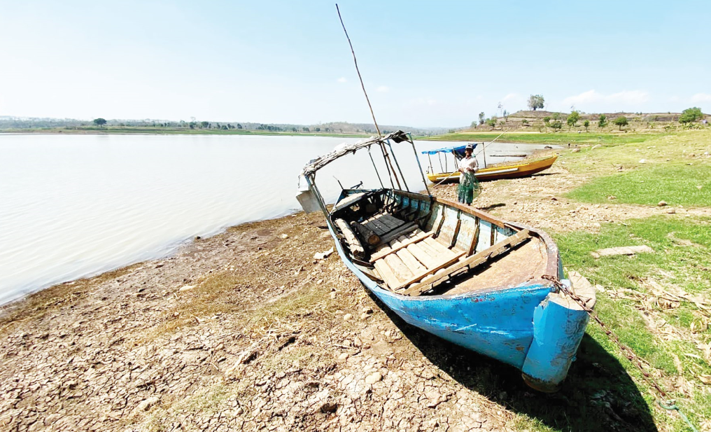 SUSUT: Volume air Waduk Dawuhan menyusut drastis, terlihat perahu milik warga terparkir di pinggir bendungan, Senin (26/8).&nbsp;(DIAN RAHAYU/RADAR MADIUN)