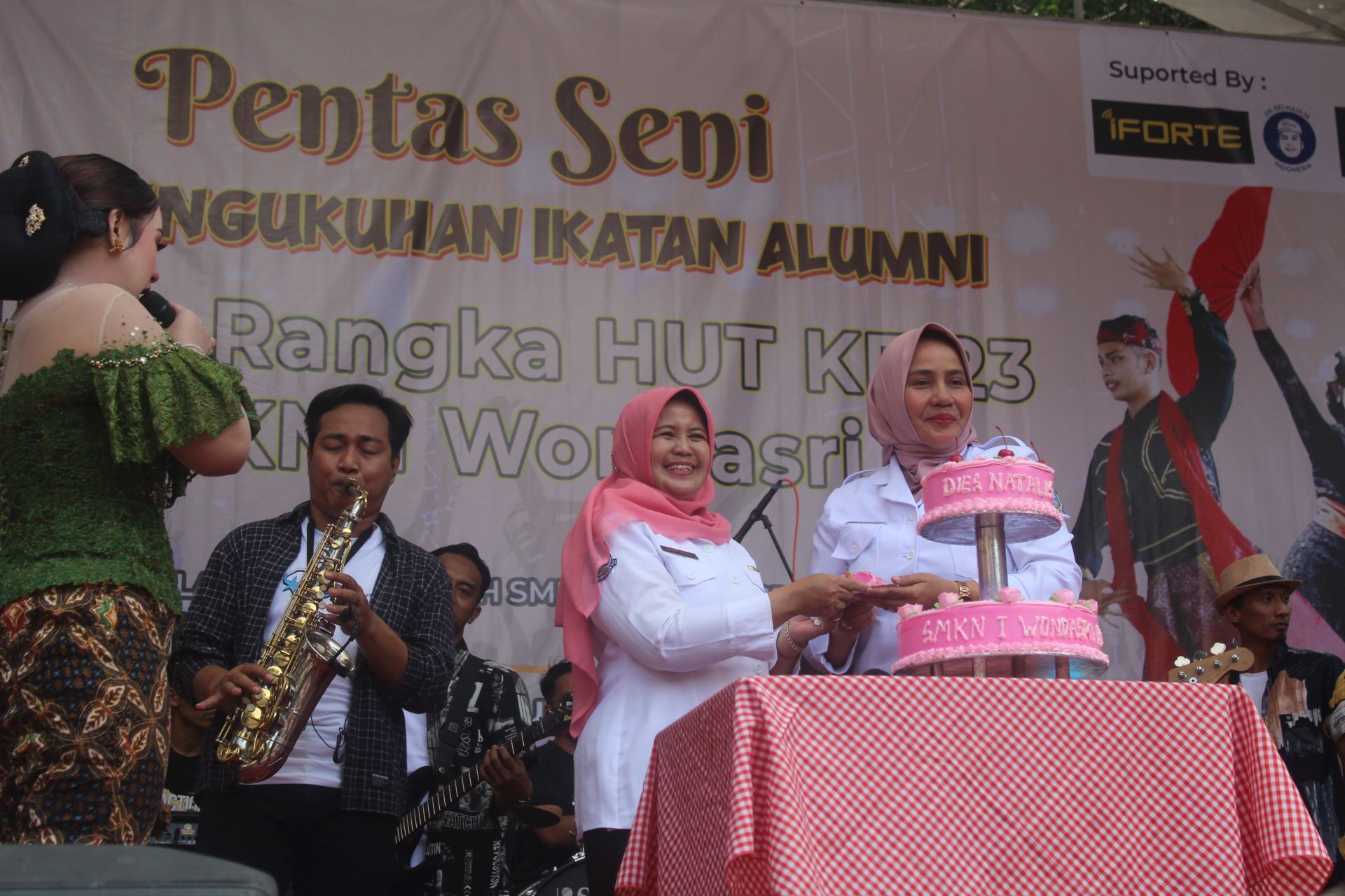 SPEKTAKULER: Kacabdindik Wilayah Madiun-Ngawi Lena dan Kepala SMKN 1 Wonoasri Wiwik Wiyati memotong kue tanda peringatan HUT SMKN 1 Wonoasri.&nbsp;(ABRIANTO WIBOWO/RADAR MADIUN)