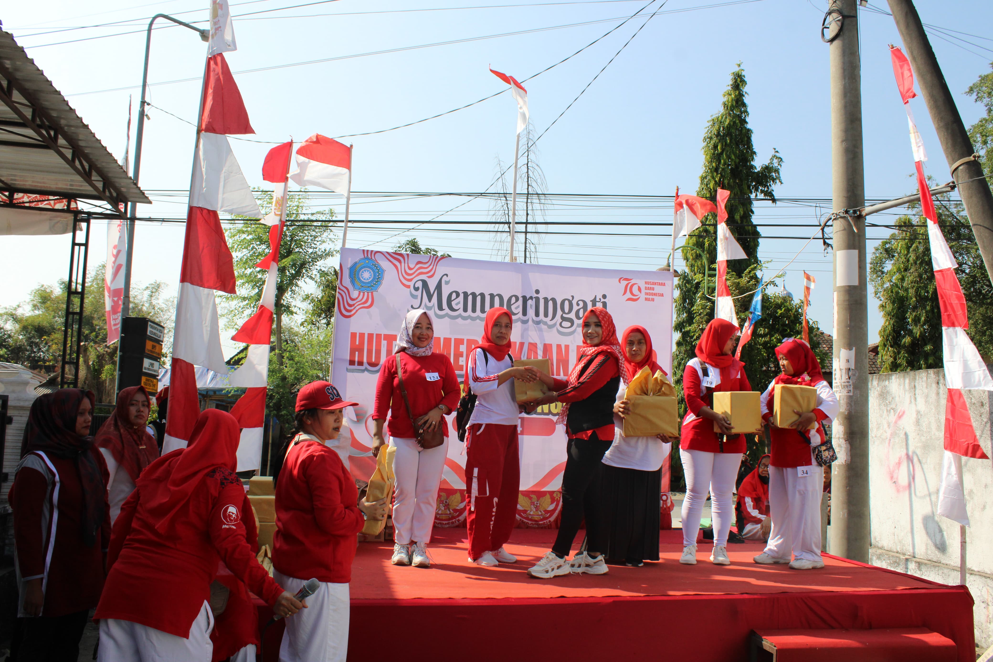 BAGI DOOR PRIZE: Ibu-ibu peserta senam aerobik bagi-bagi doorprize untuk memeriahkan acara. (PEMDES KEDUNGGALAR)
